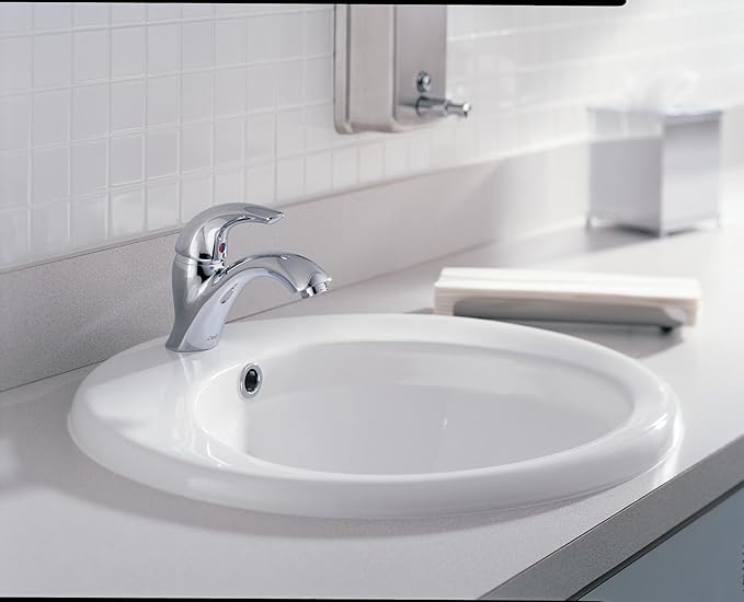 Chrome single-handle bathroom faucet with lever control mounted on white sink countertop.