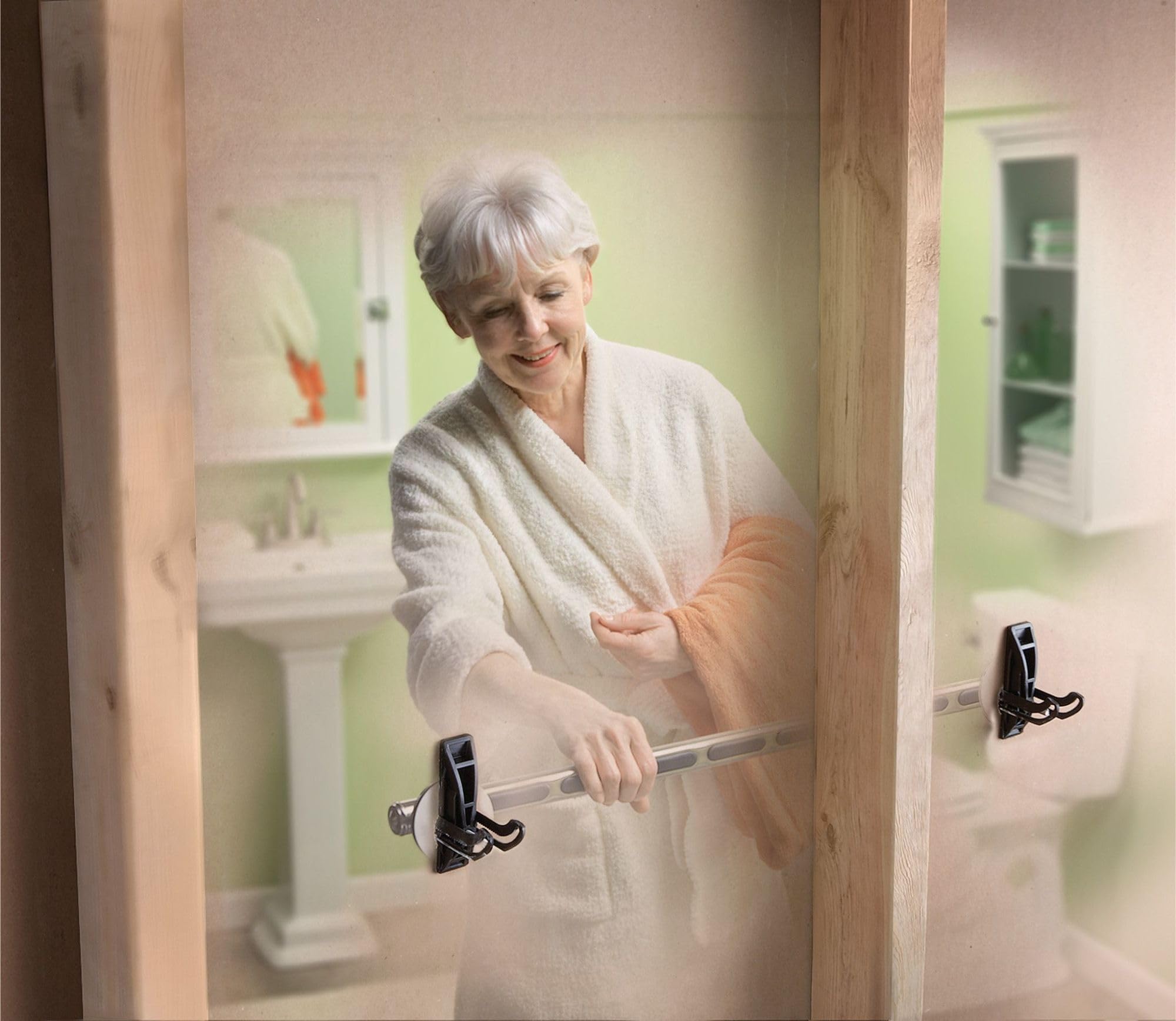 Older woman holding horizontal grab bar with black anchor brackets mounted on bathroom wall framing.