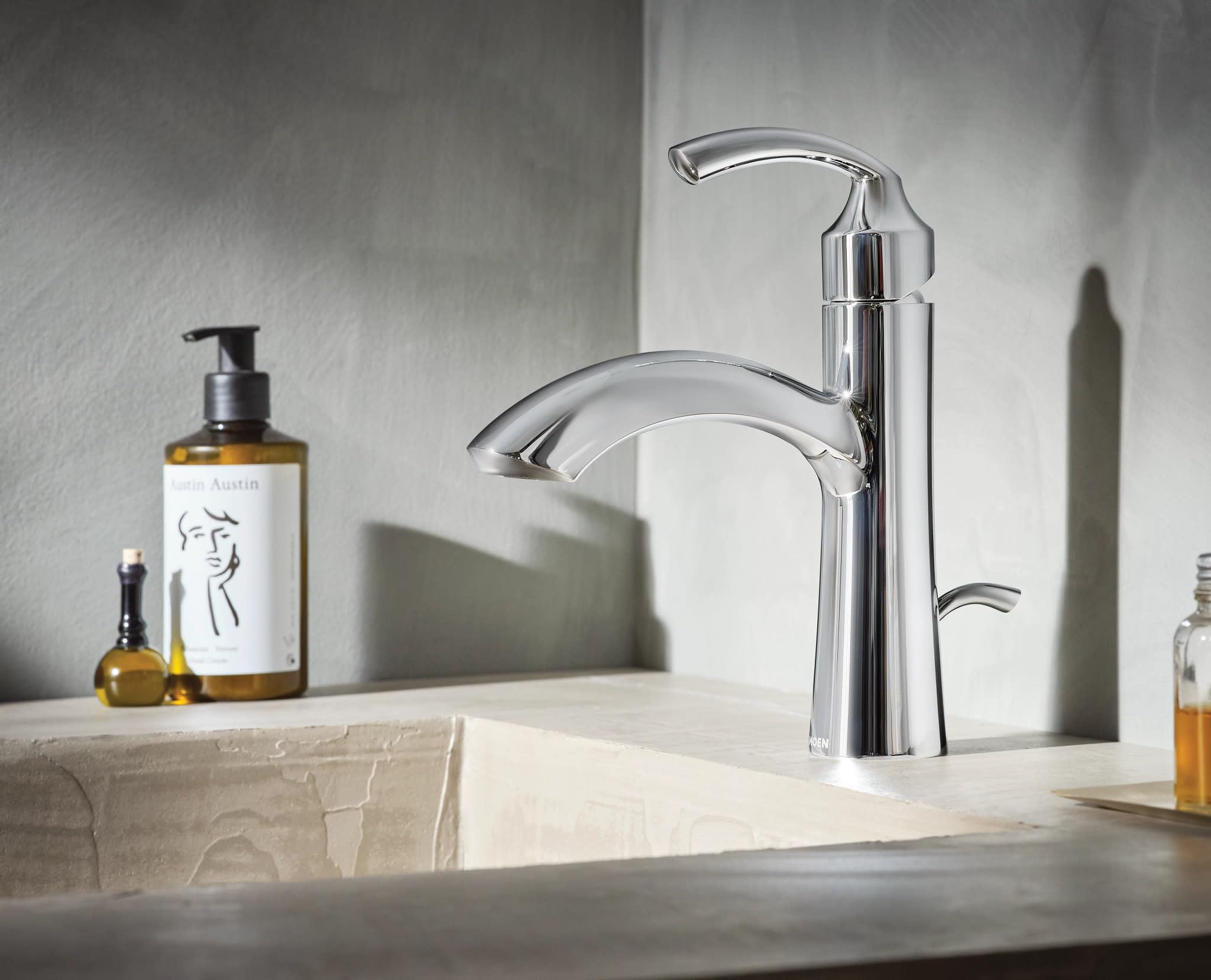 Chrome single-handle bathroom sink faucet with curved spout and lever handle mounted on countertop.