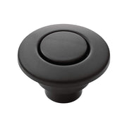 Matte black round air switch button with recessed center and cylindrical stem for garbage disposal.