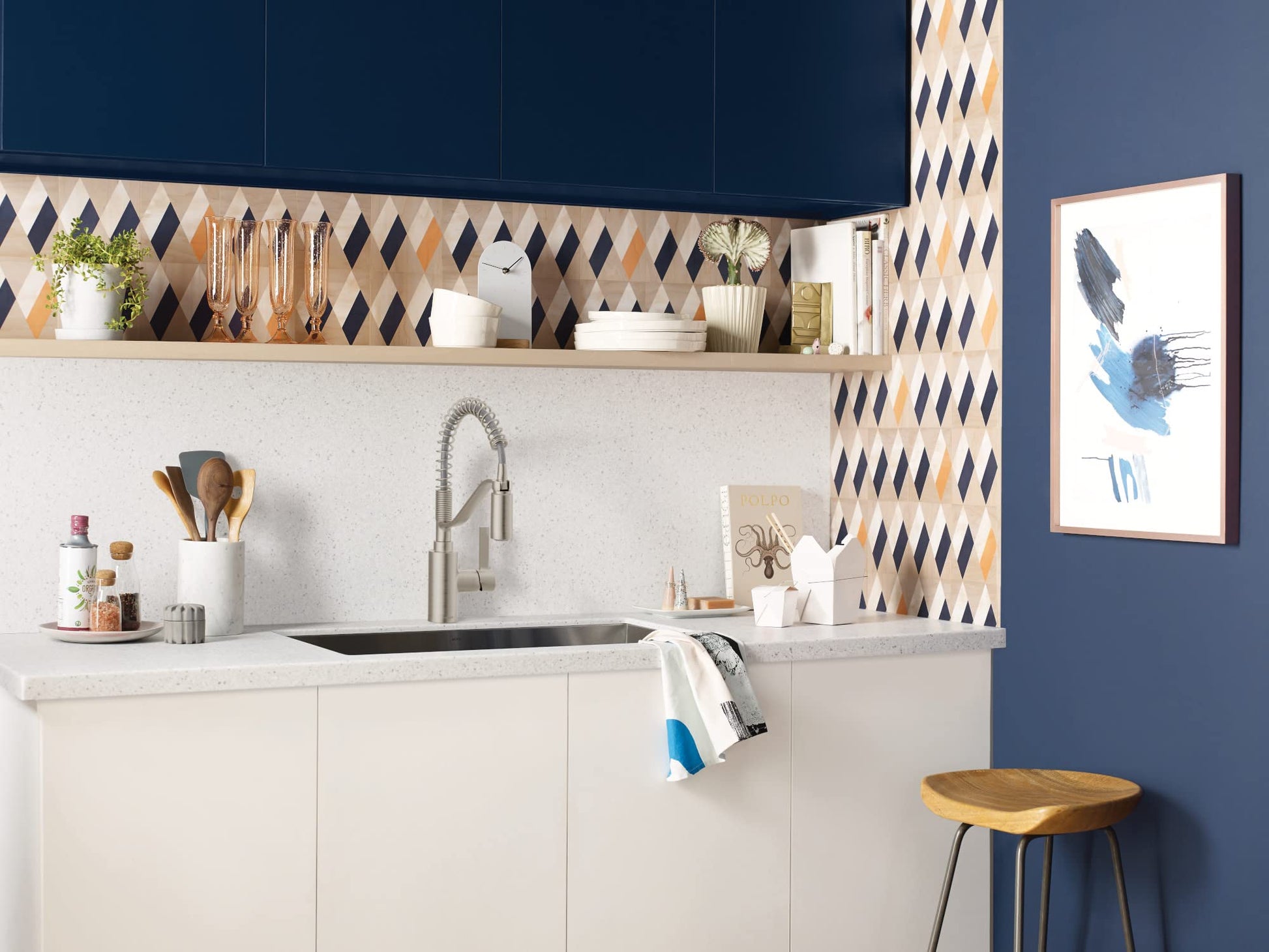 Stainless steel pull-down kitchen faucet with single handle mounted above black sink in modern kitchen.