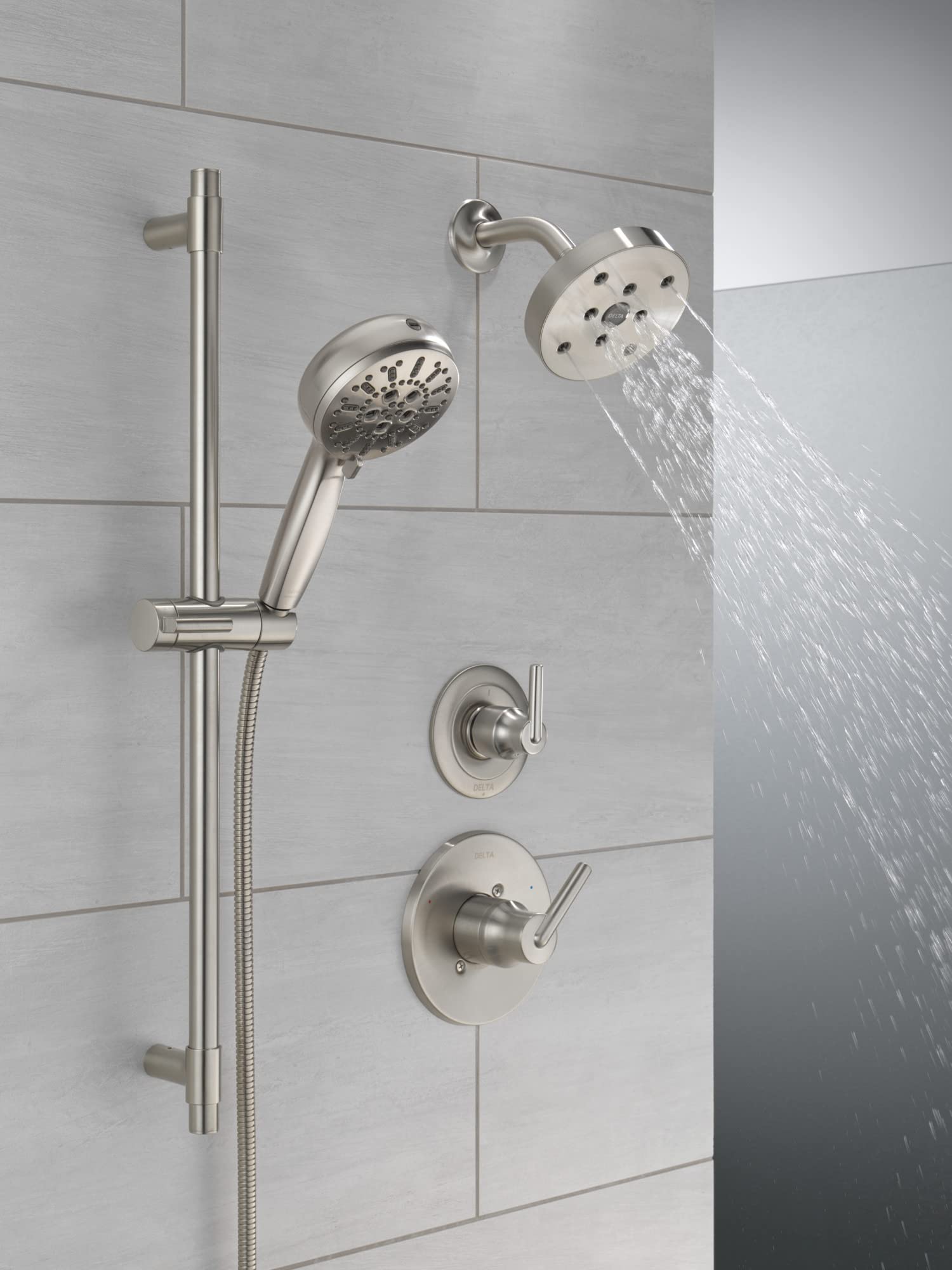 Stainless steel shower system with slide bar hand shower, fixed overhead spray head, and dual valve controls mounted on white