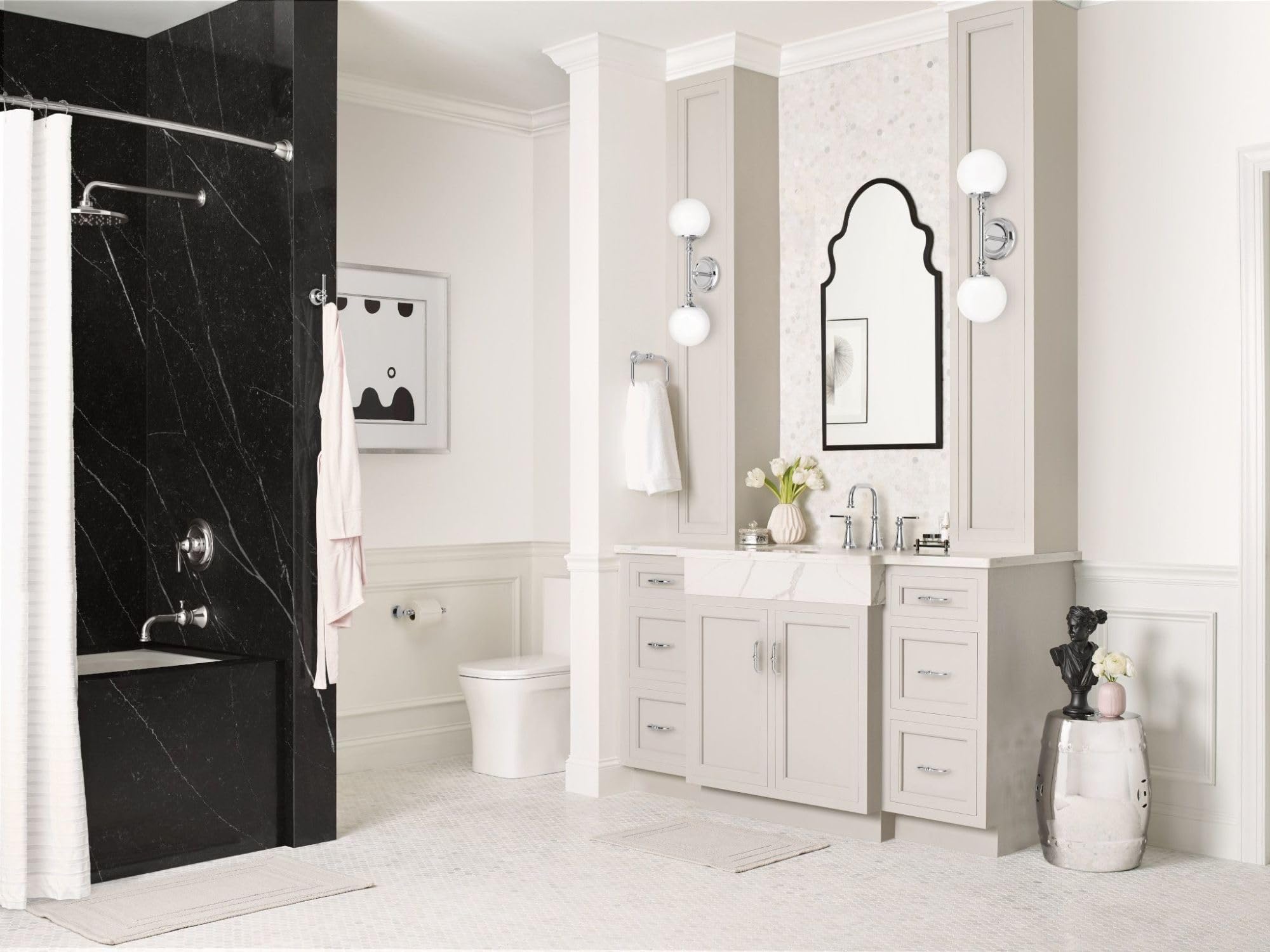 Chrome single-handle tub and shower trim kit mounted on black marble shower wall with white subway tile surround.