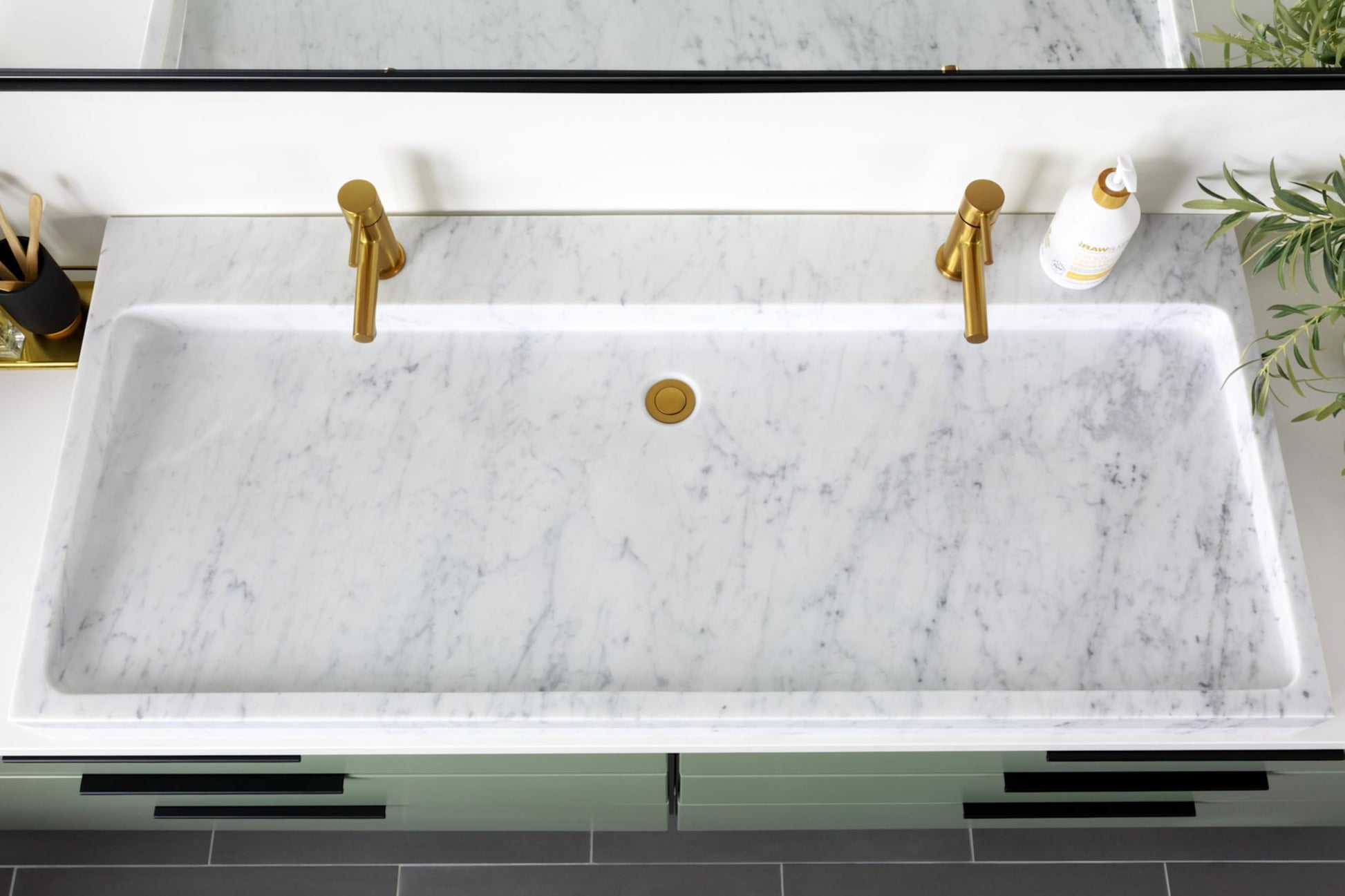 Brushed nickel single-handle low-arc bathroom faucet mounted on marble sink countertop.