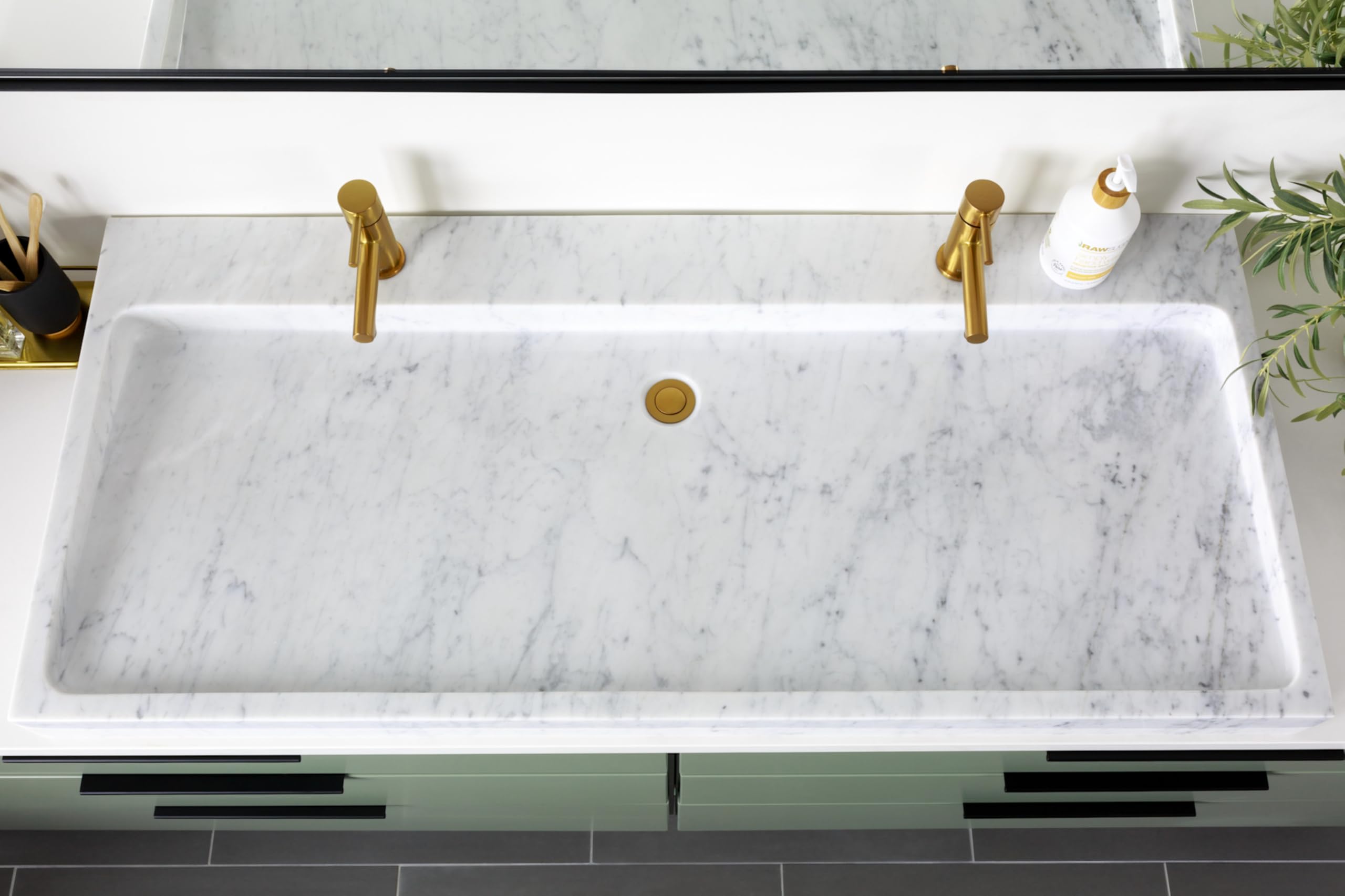 Brushed nickel single-handle low-arc bathroom faucet mounted on marble sink countertop.