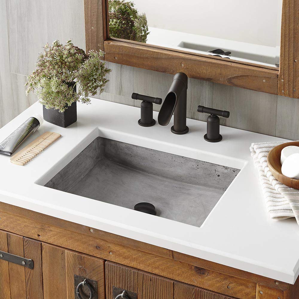 White rectangular bathroom sink with gray concrete basin and black faucet on wooden vanity.