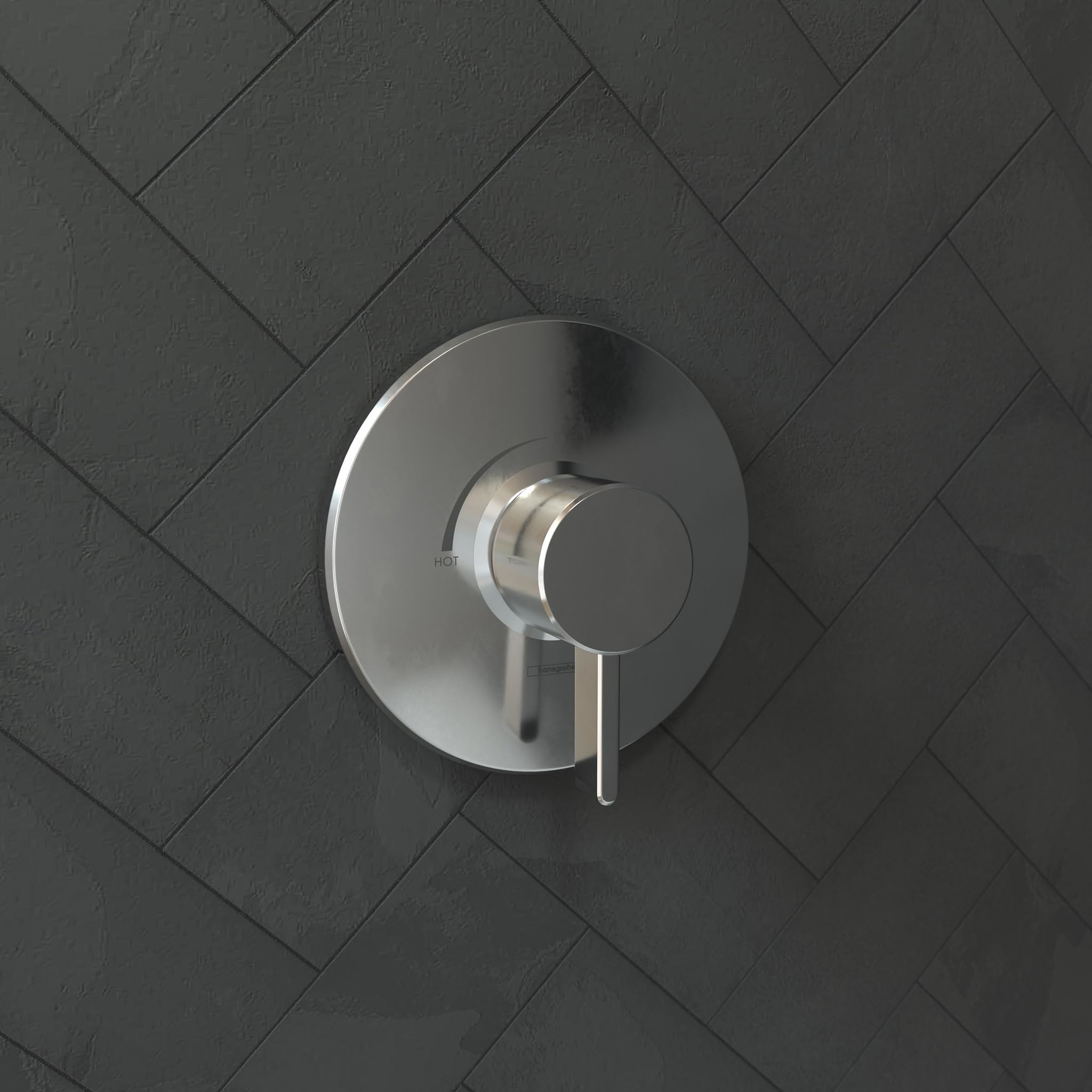 Chrome pressure balance shower valve trim with circular escutcheon plate and lever handle mounted on herringbone tile wall.