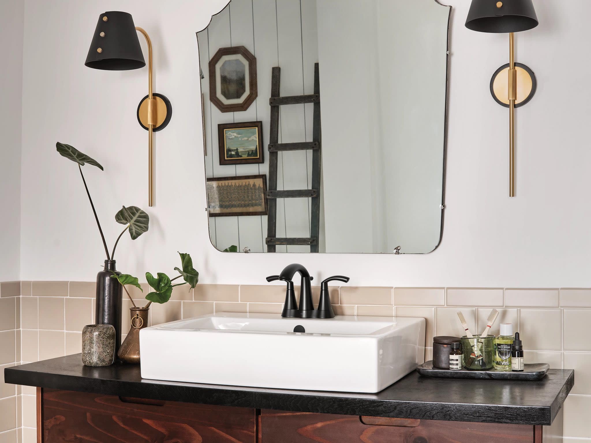 Matte black two-handle high arc faucet with curved spout installed on white rectangular vessel sink.