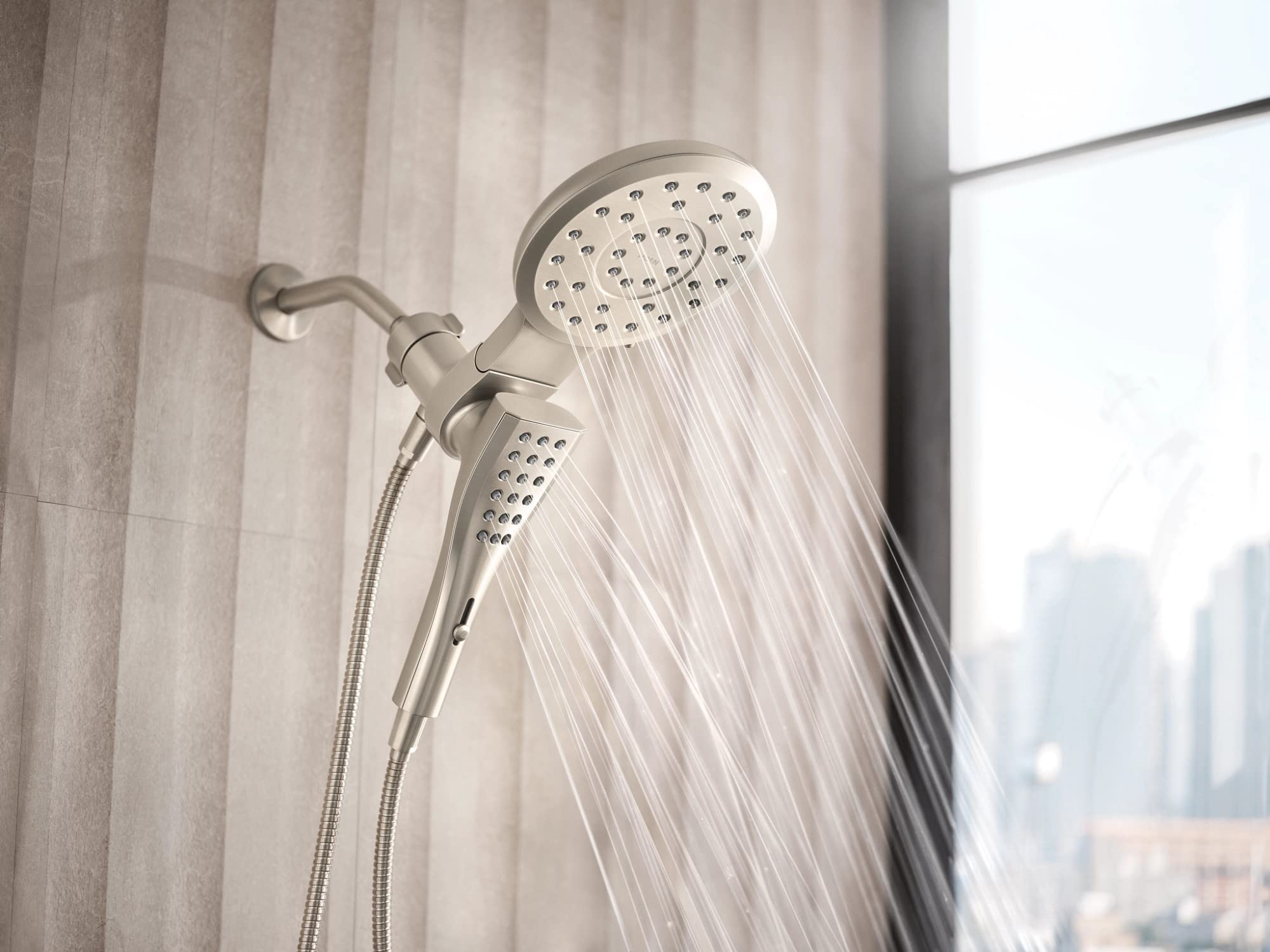 Brushed nickel 7-inch round shower head with handheld spray and 72-inch hose mounted on bathroom wall.