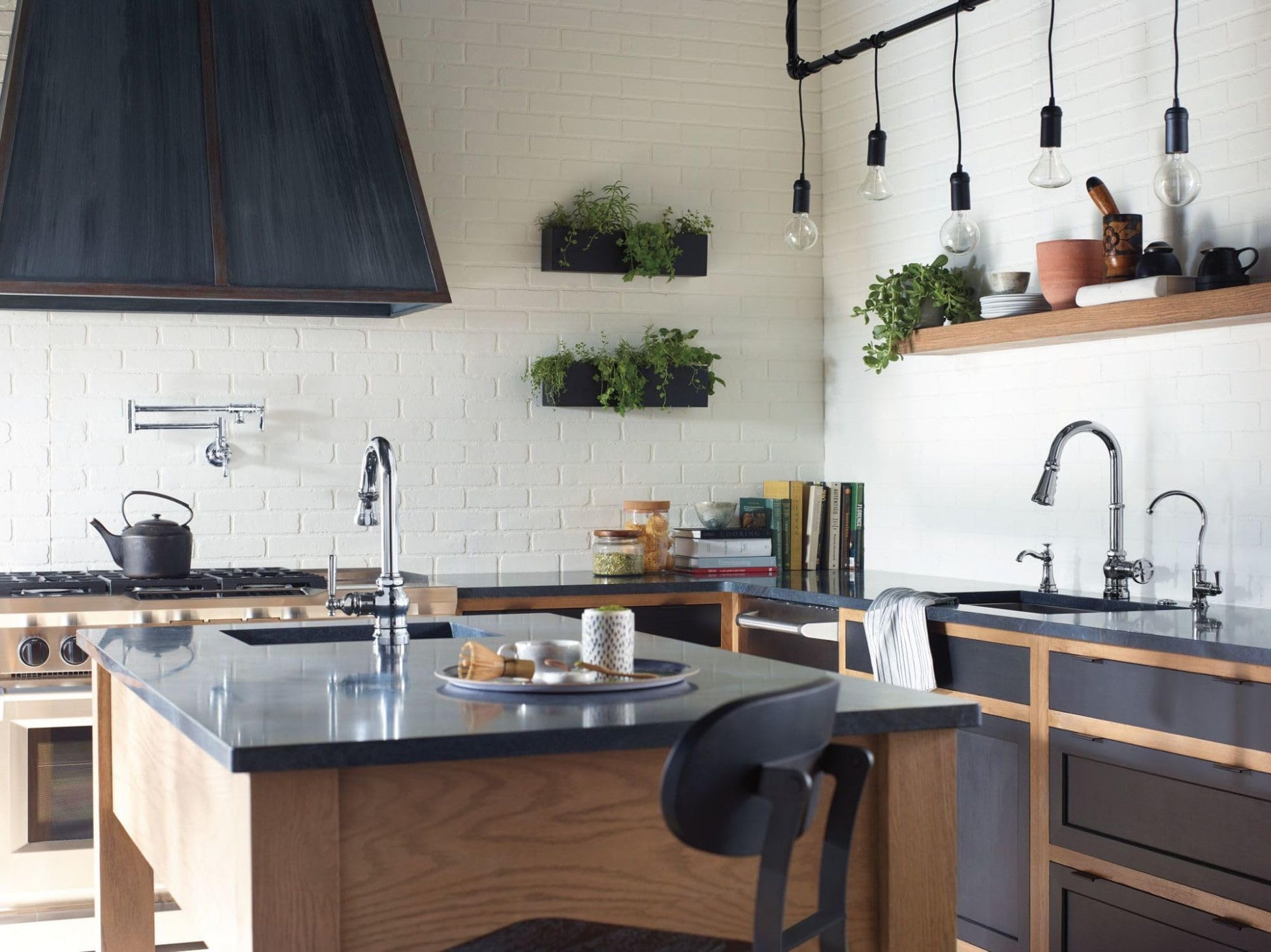Chrome pulldown bar faucet with single handle mounted on kitchen sink countertop.