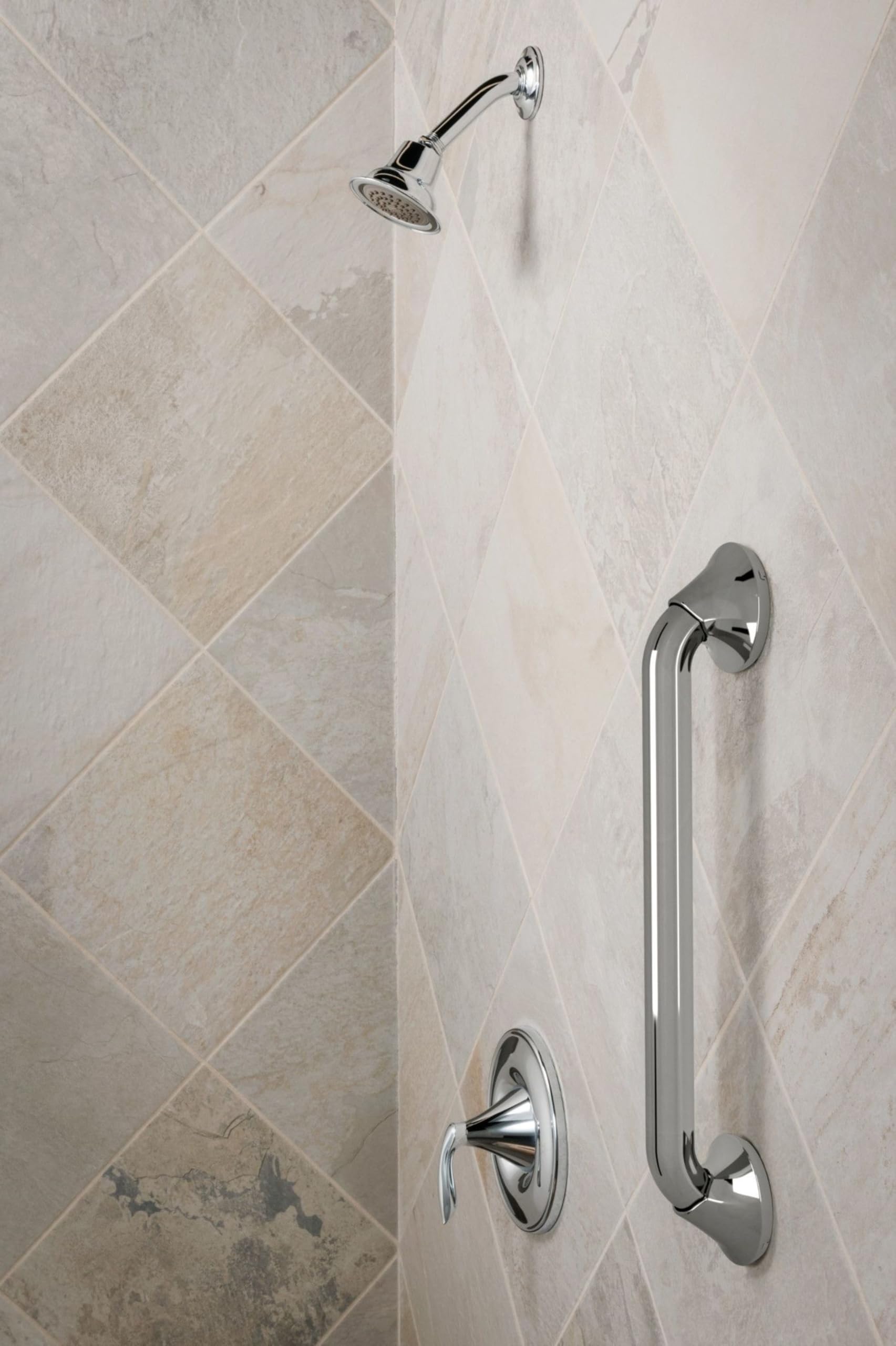 Chrome stainless steel grab bar mounted vertically on tile shower wall next to showerhead and valve controls.