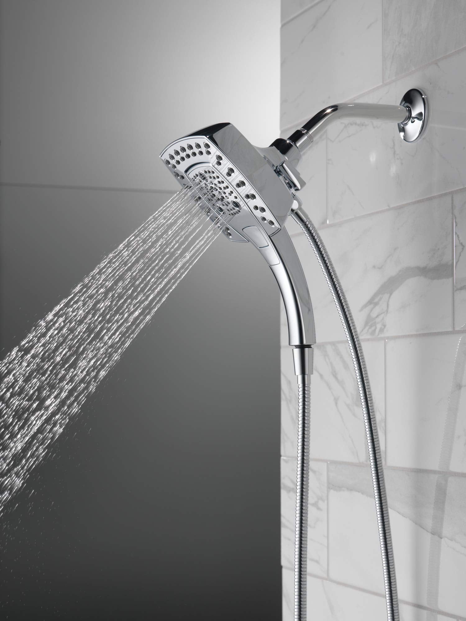 Chrome two-in-one shower head with hand spray and flexible hose mounted on wall tile.