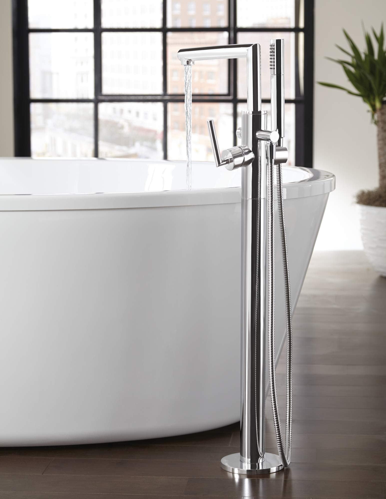 Chrome freestanding tub filler with single riser, floor mount, and handheld shower head with hose.