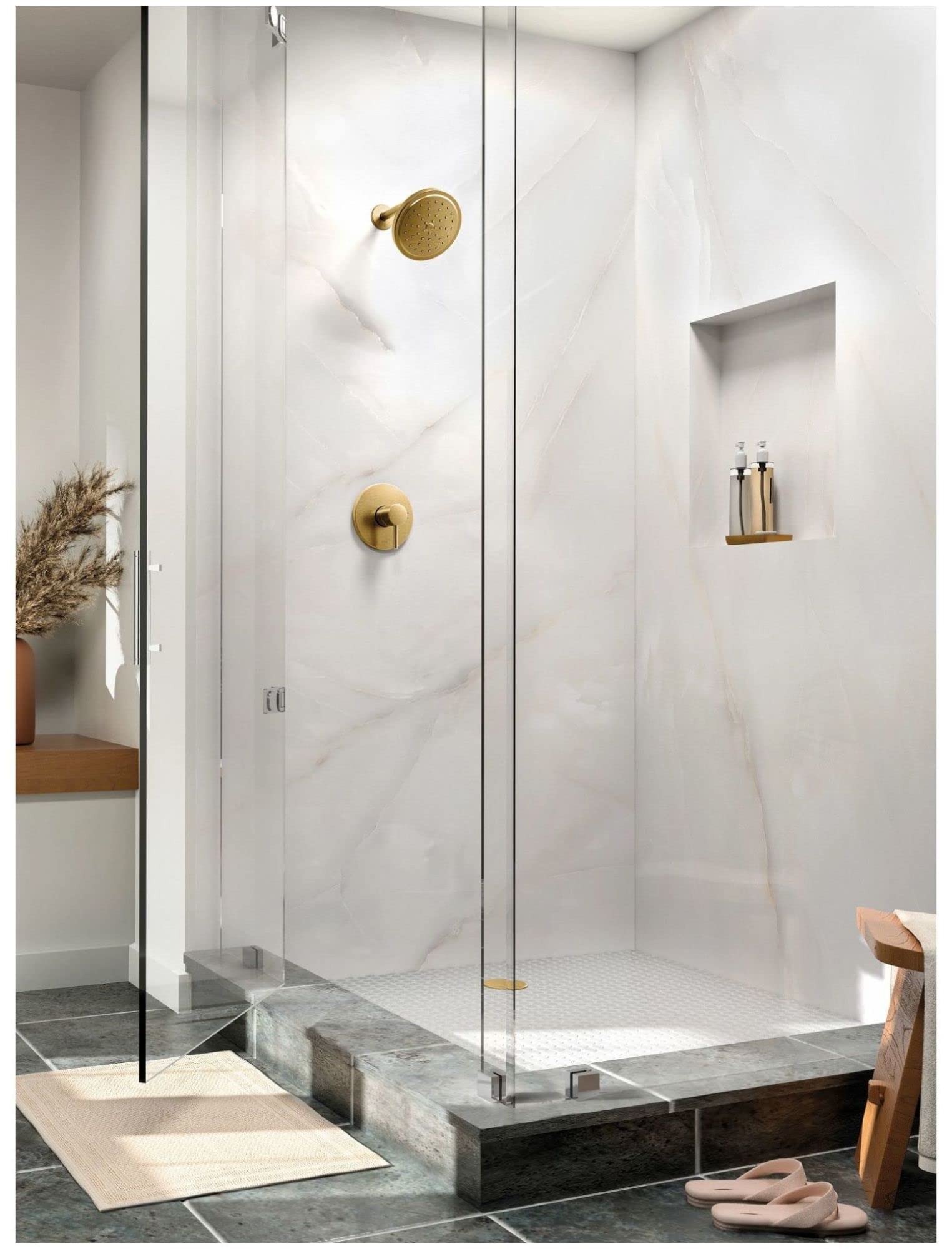 Brushed gold shower trim with single handle and round showerhead mounted on marble tile bathroom wall.