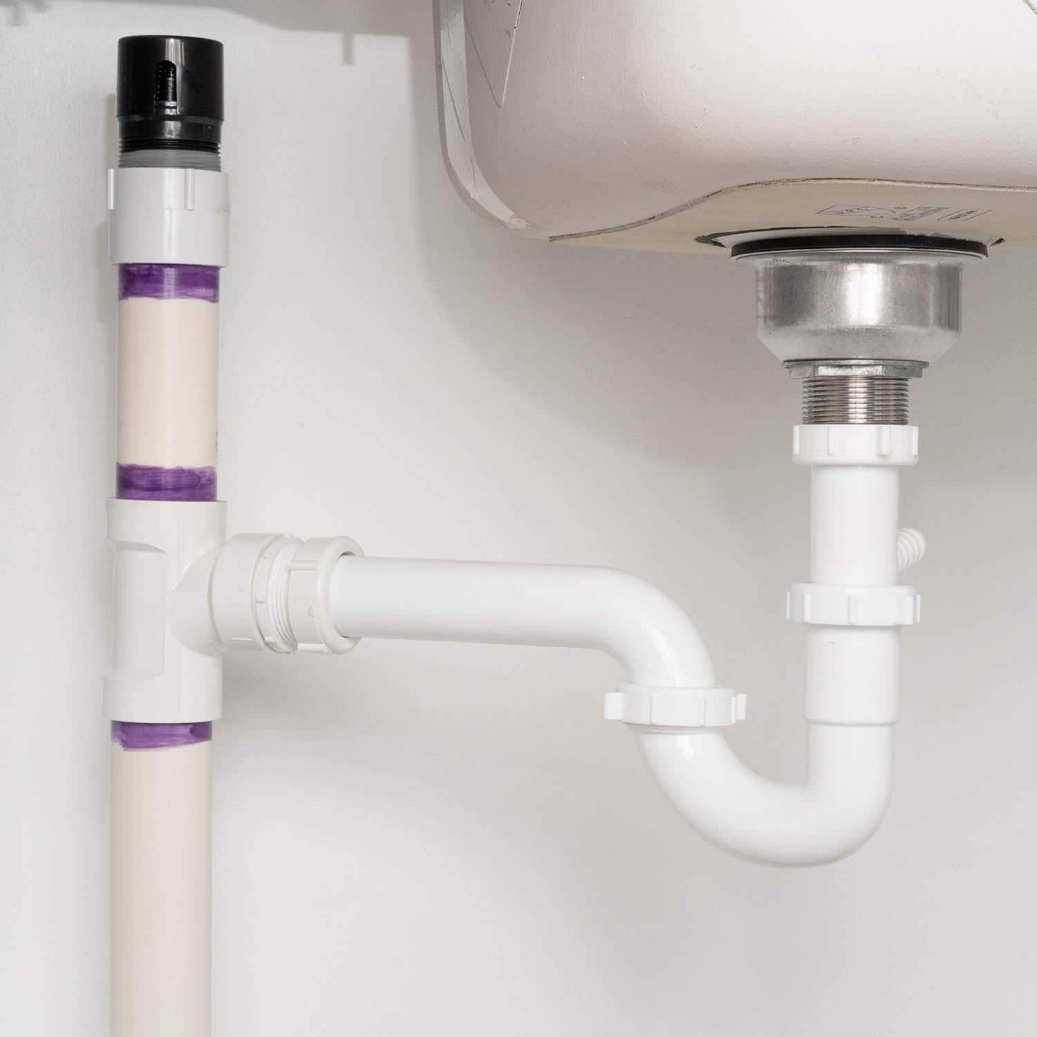 White ABS plastic inline vent with black cap and purple identification bands, shown installed in drain pipe assembly.