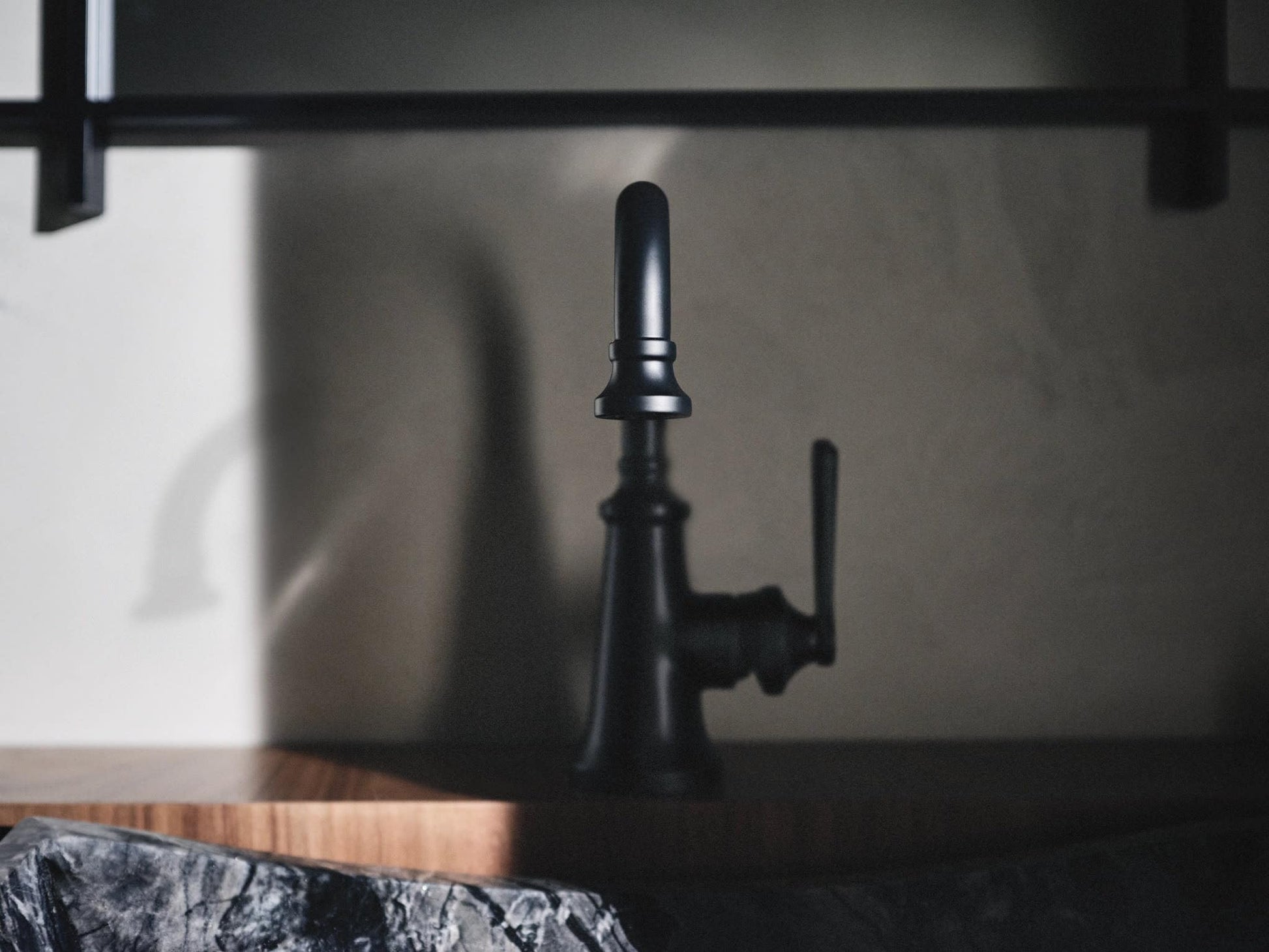 Matte black single-handle bathroom faucet with tall spout and lever handle on countertop.