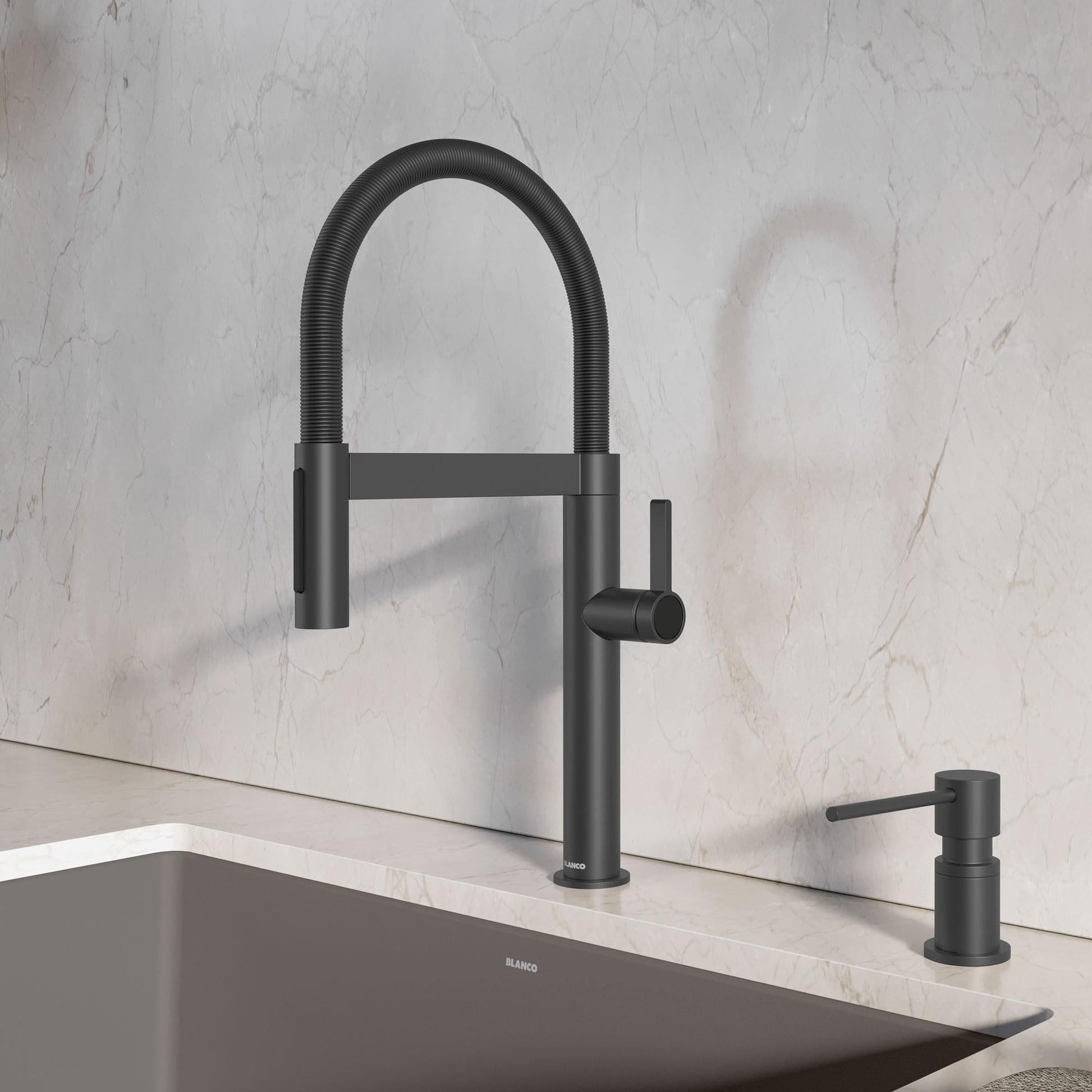 Matte black pull-down kitchen faucet with flexible hose spout and matching soap dispenser on marble countertop.