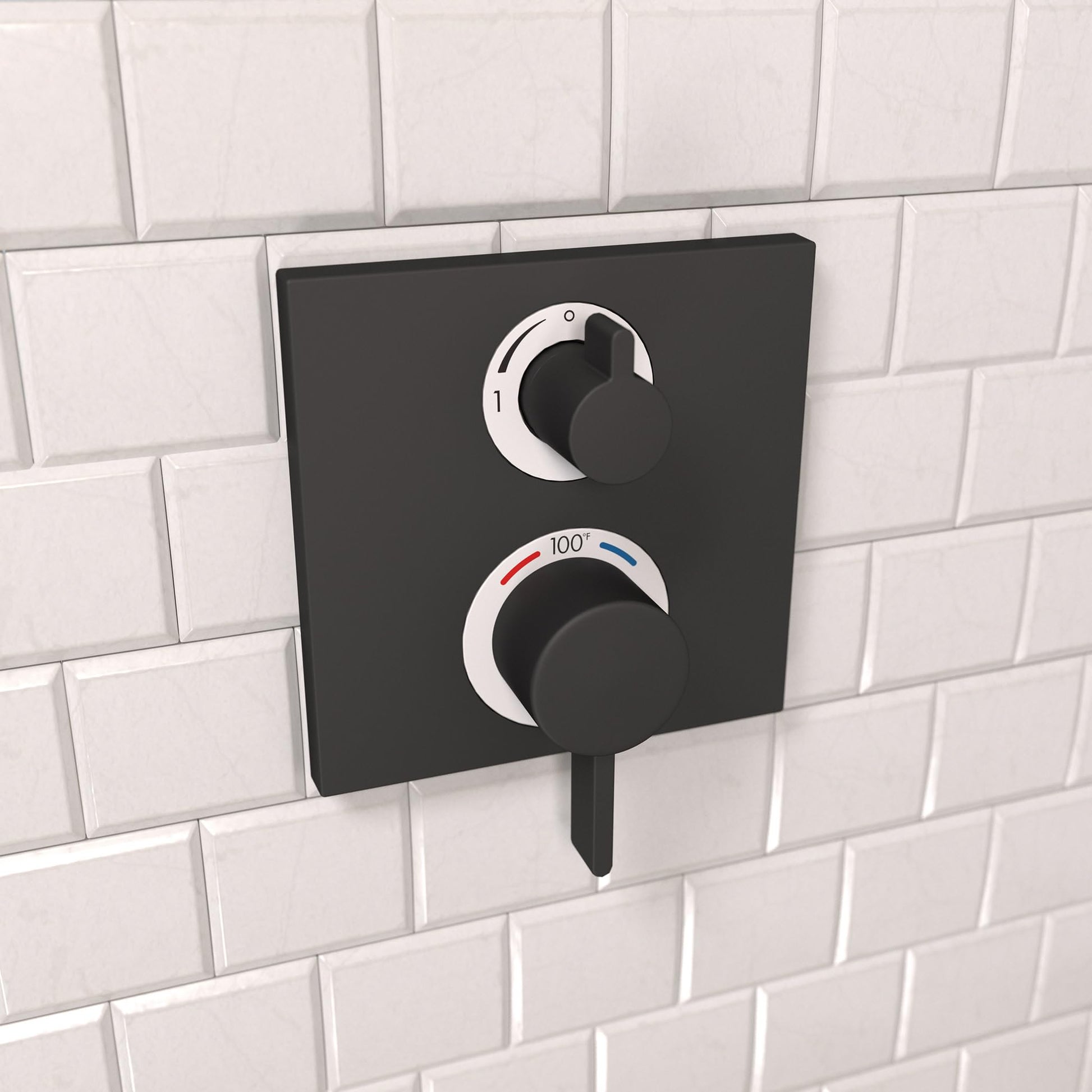 Matte black thermostatic shower trim with two circular control knobs mounted on white subway tile wall.