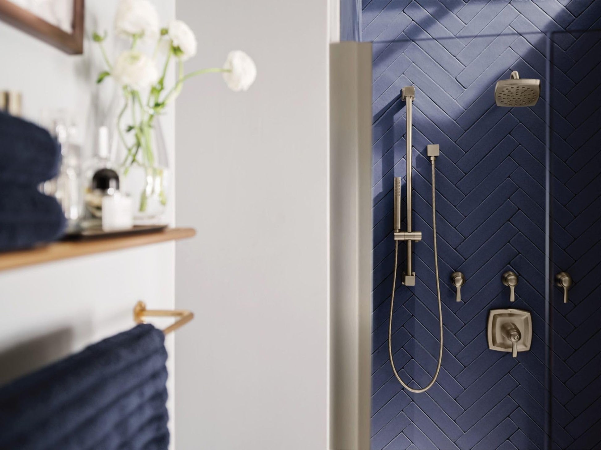 Brushed nickel shower valve trim with square control handle, handheld showerhead, and overhead rainfall showerhead on dark ti