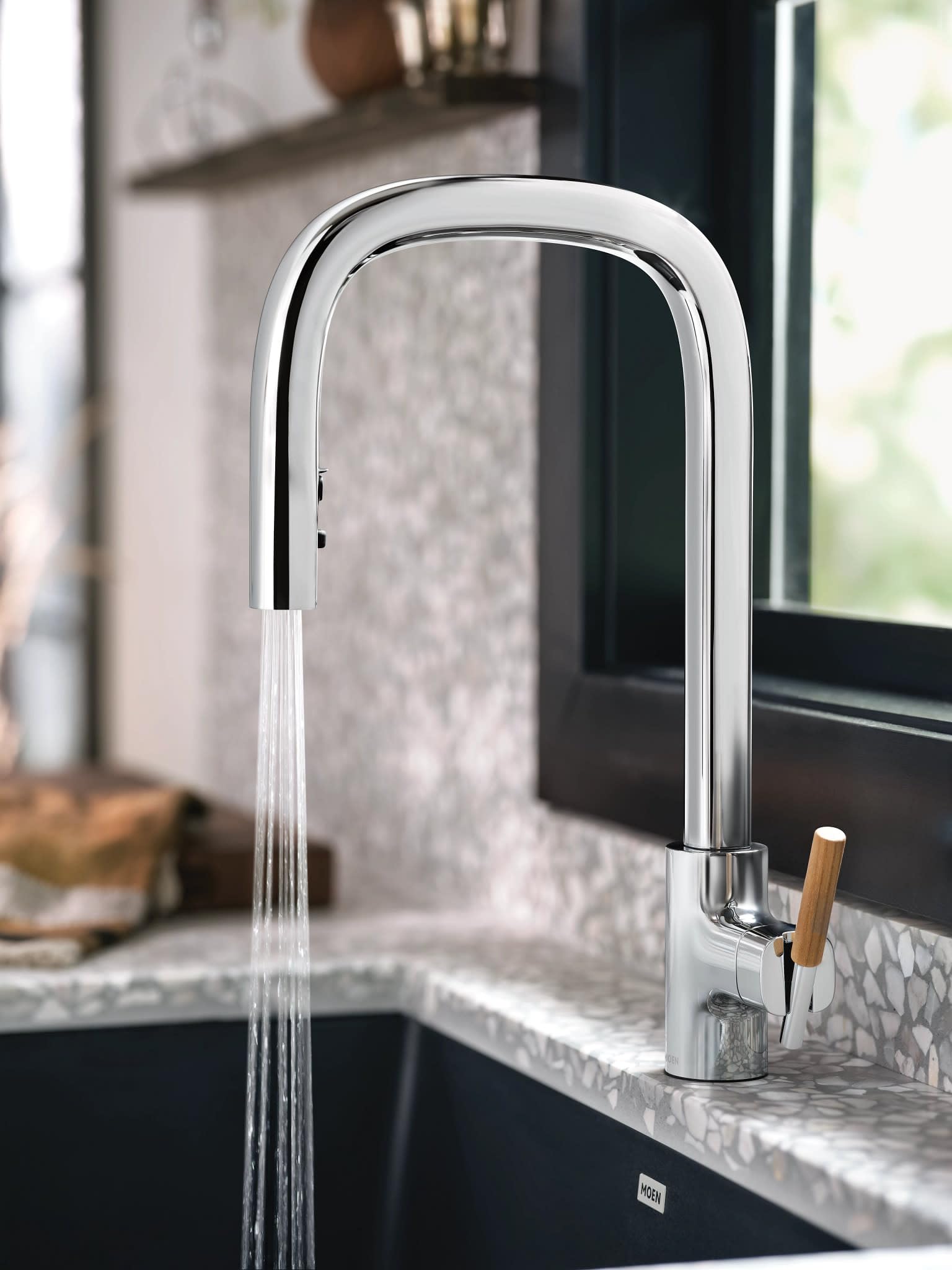 Chrome kitchen faucet with tall arched spout, pulldown spray head, and wood accent handle on countertop sink.
