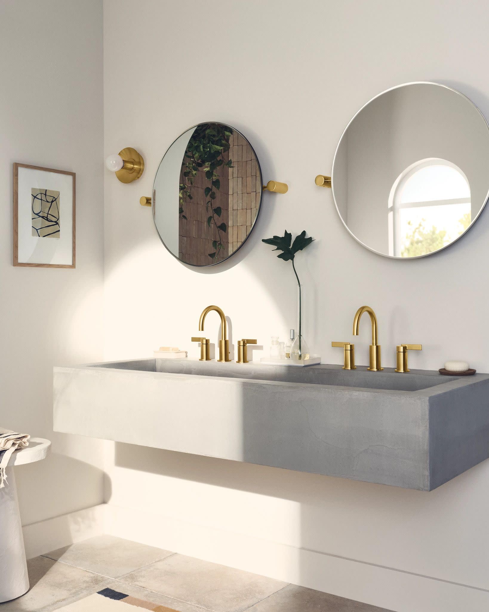 Brushed gold two-handle high arc faucet with curved spout installed on double sink vanity.