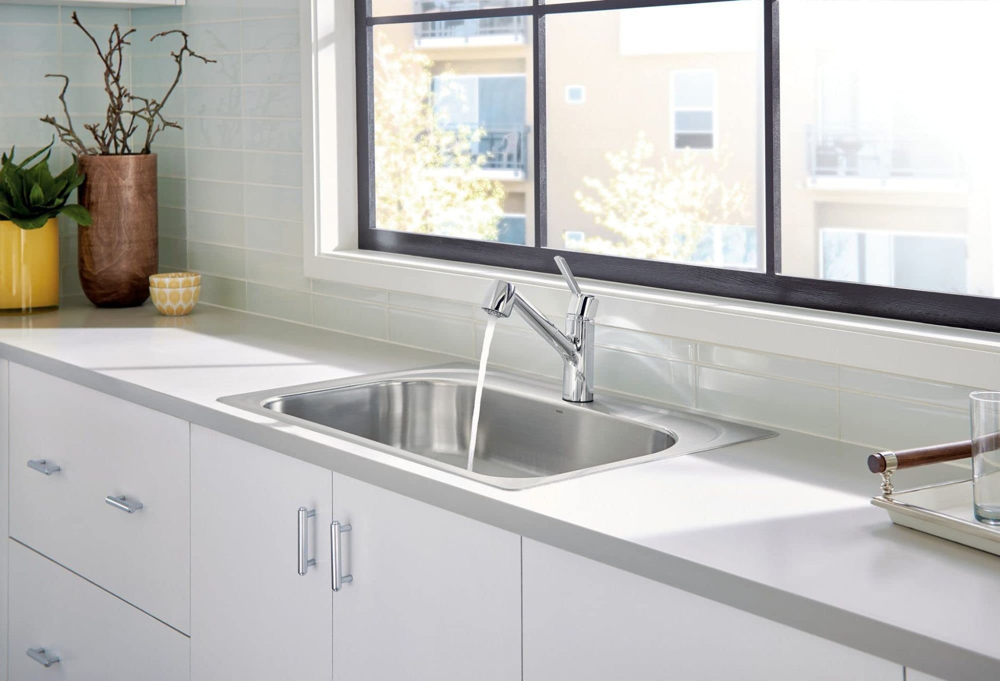 Chrome single-handle kitchen faucet with pullout sprayer mounted above stainless steel sink.