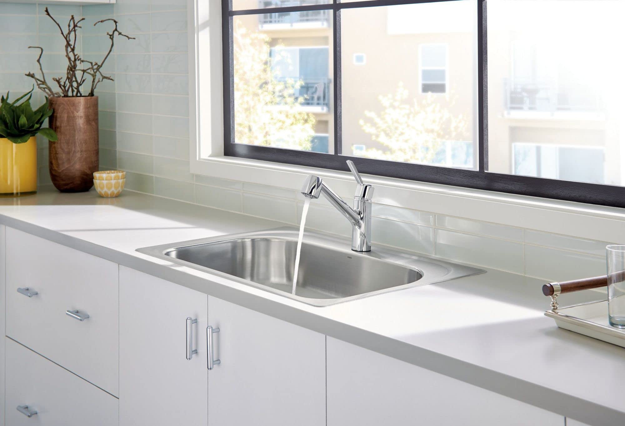 Chrome single-handle kitchen faucet with pullout sprayer mounted above stainless steel sink.