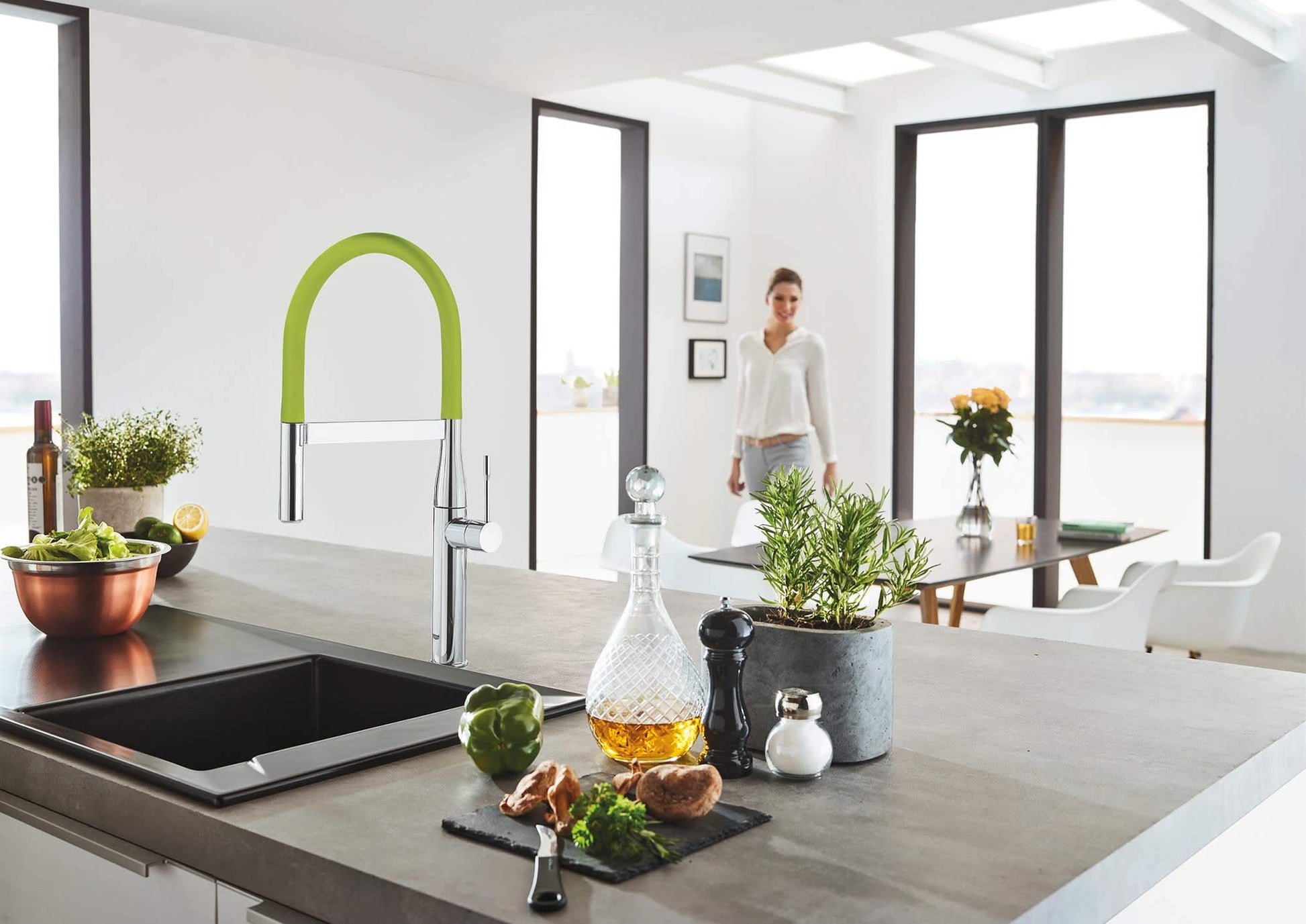 Red and chrome pull-down kitchen faucet with flexible hose and high curved spout over sink.