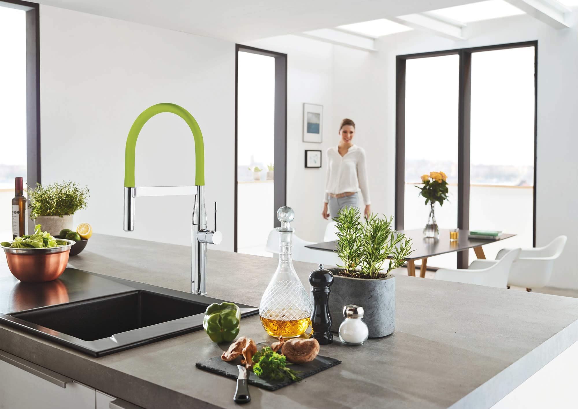 Red and chrome pull-down kitchen faucet with flexible hose and high curved spout over sink.