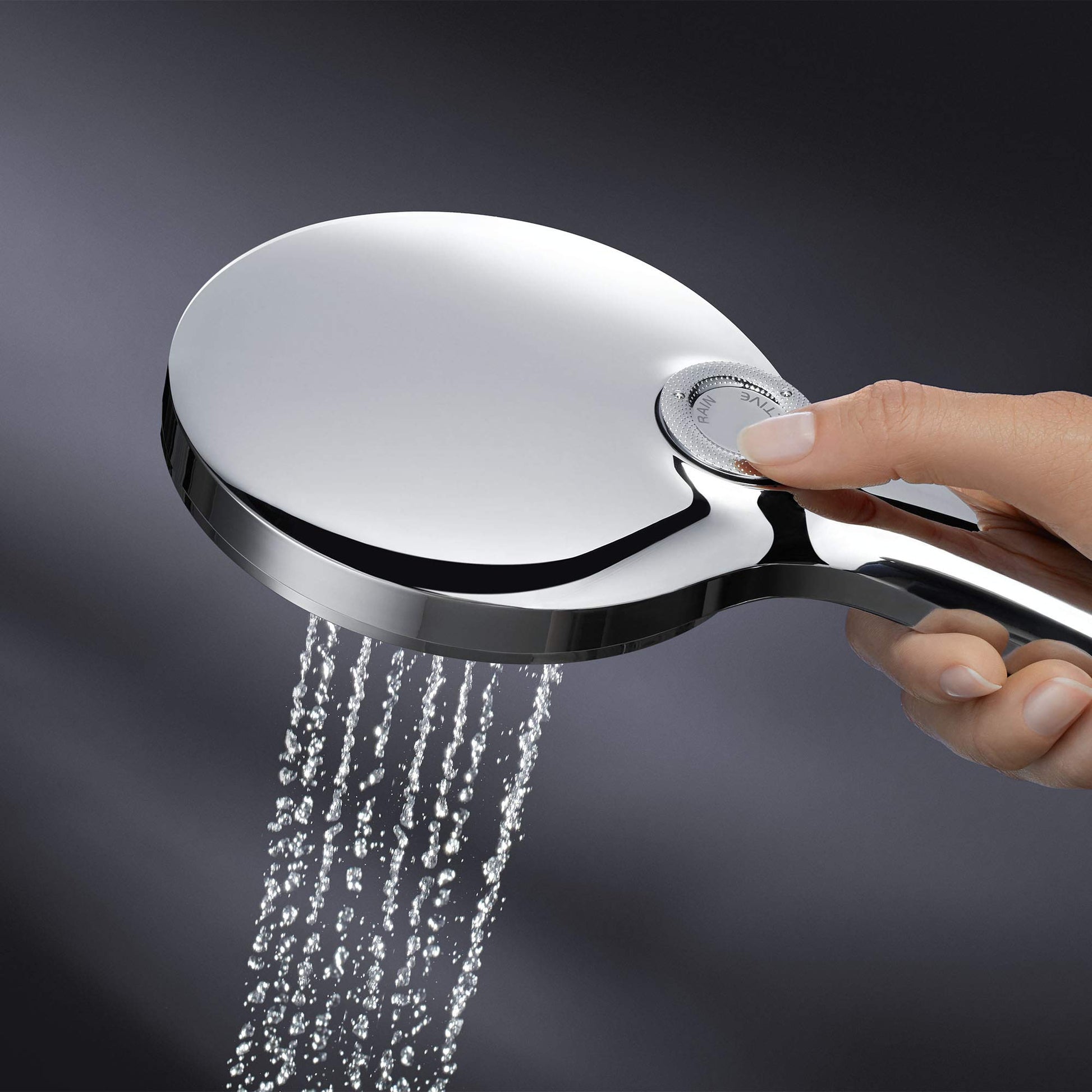 Chrome hand shower with large oval head and black trim held in hand with water spraying downward.