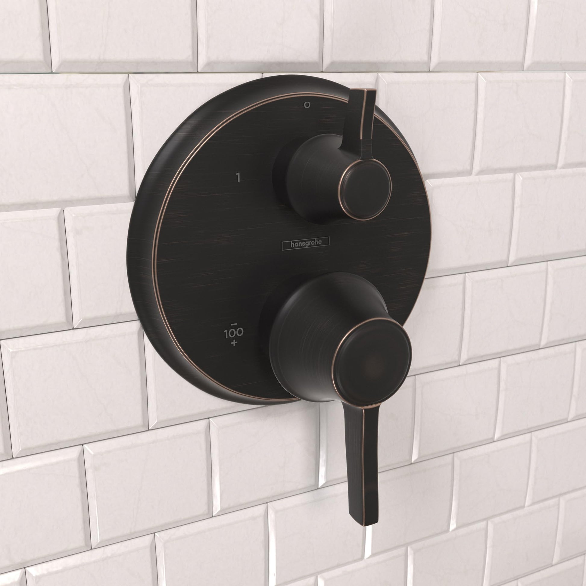Round rubbed bronze thermostatic shower trim with dual control handles mounted on white subway tile.