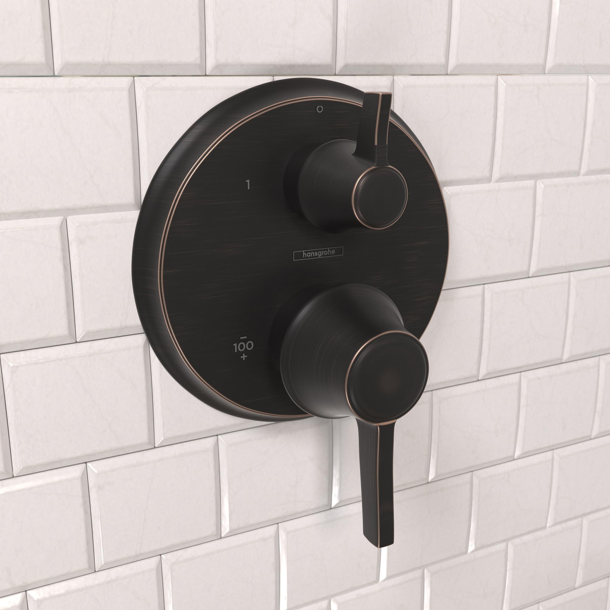 Round rubbed bronze thermostatic shower trim with dual control handles mounted on white subway tile.