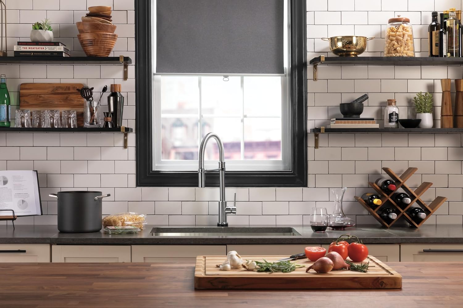 Modern kitchen sink with chrome pull-down faucet, gray countertop, white subway tile backsplash, and open shelving.