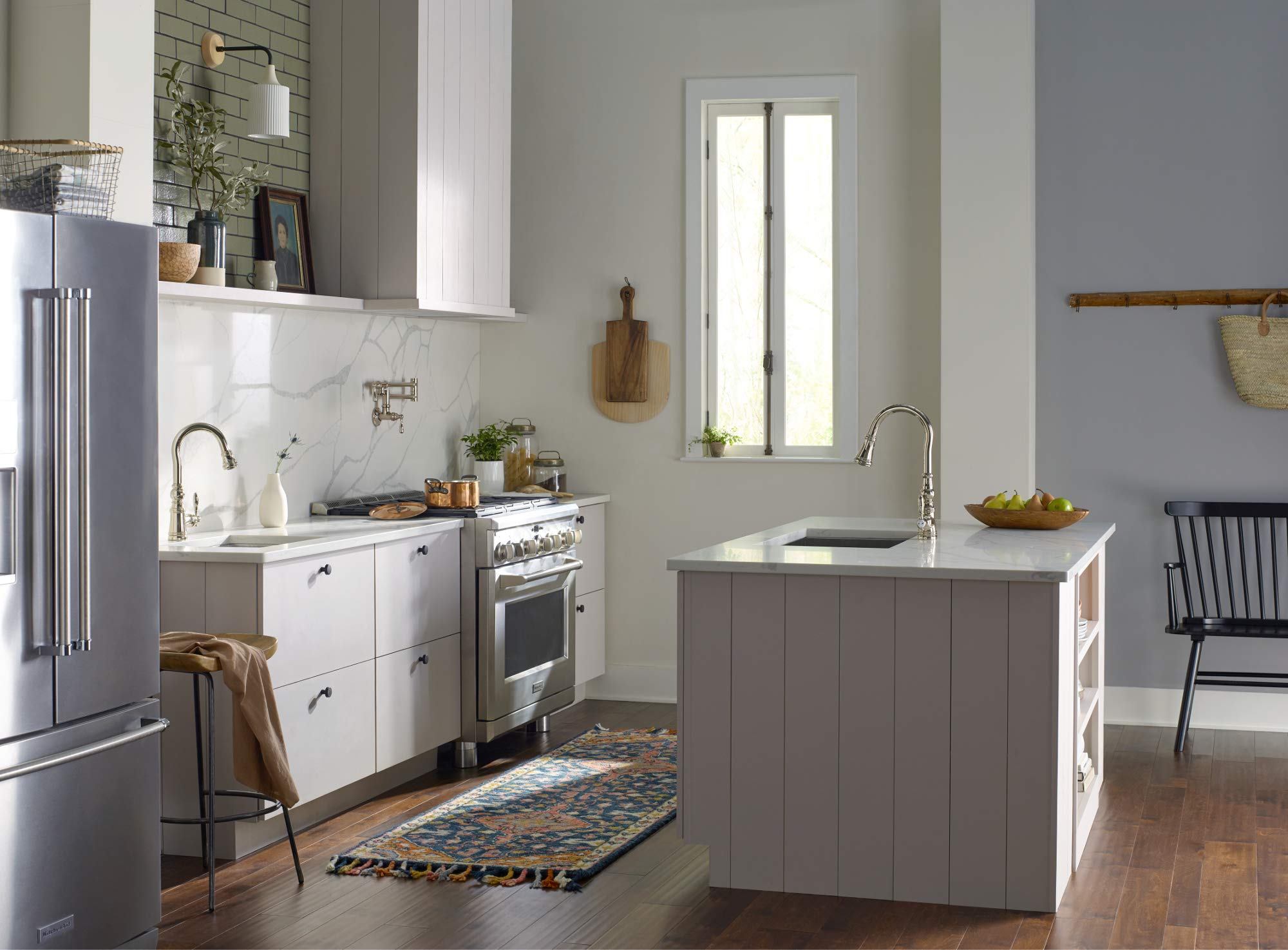Oil rubbed bronze pulldown kitchen faucet with curved spout installed on island sink.