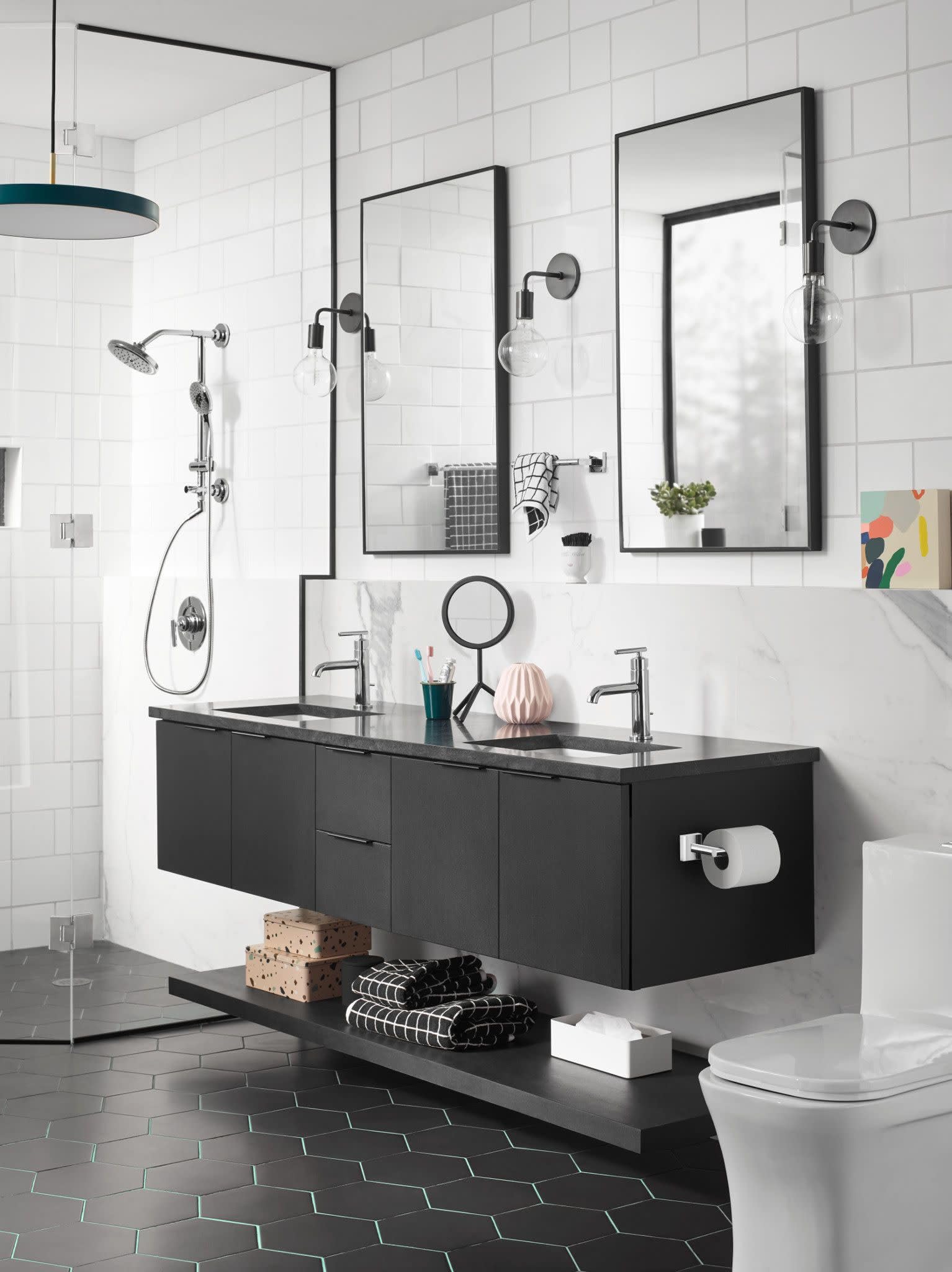 Chrome single-handle bathroom faucet with curved spout mounted on black vanity counter in modern bathroom setting.