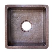 Square hammered copper sink with antique finish and circular drain hole, viewed from above.