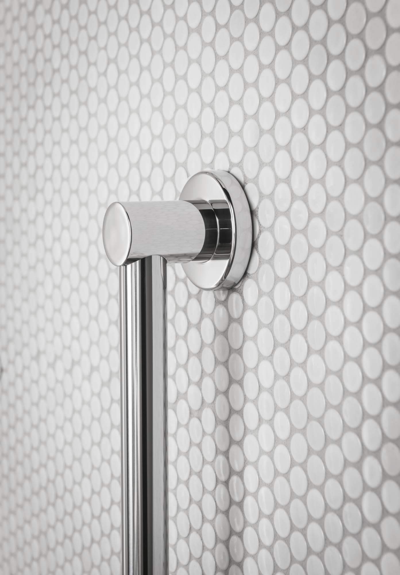 Brushed gold stainless steel grab bar mounted horizontally on white oval tile bathroom wall.