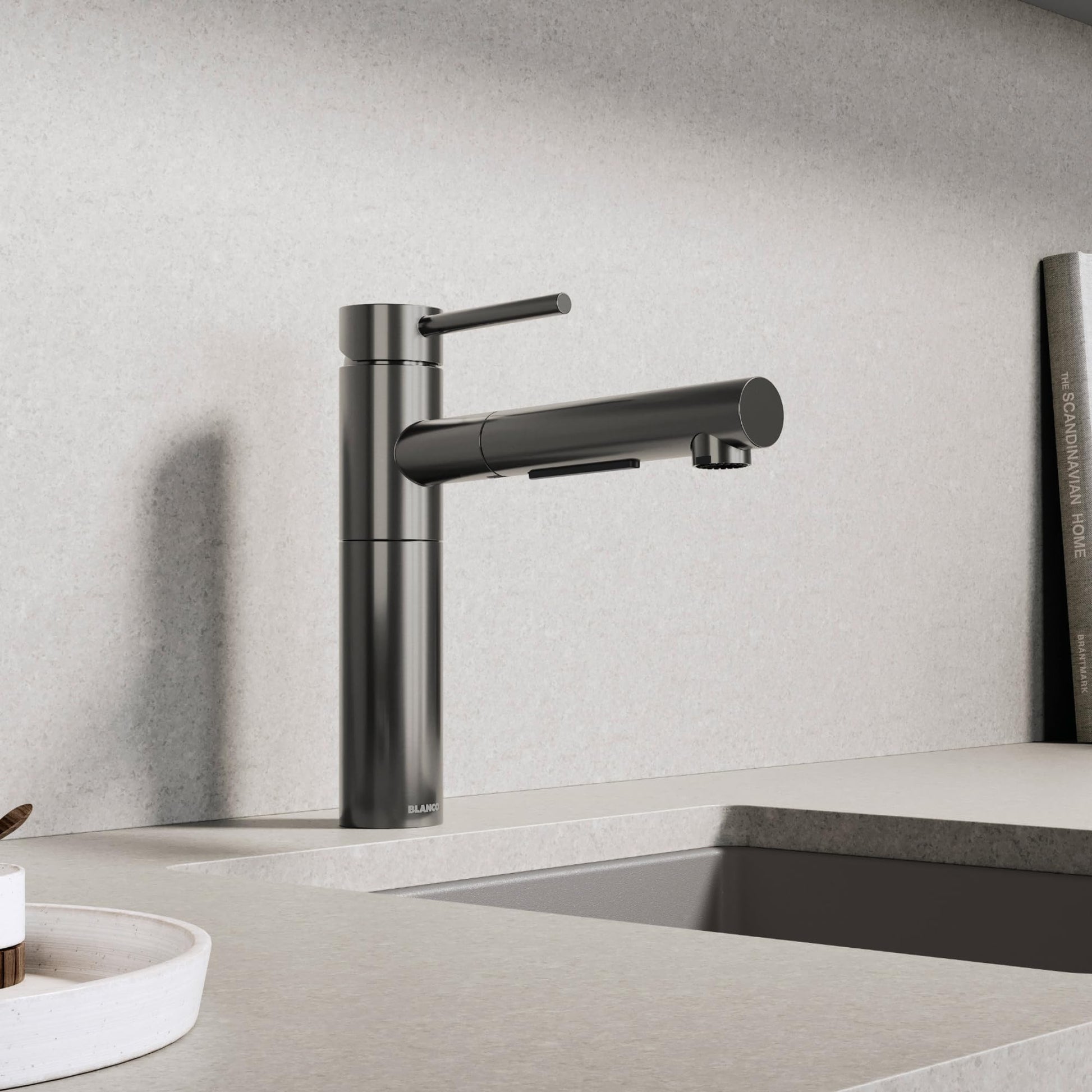Satin dark steel pull-out kitchen faucet with single handle lever and cylindrical spout over sink.