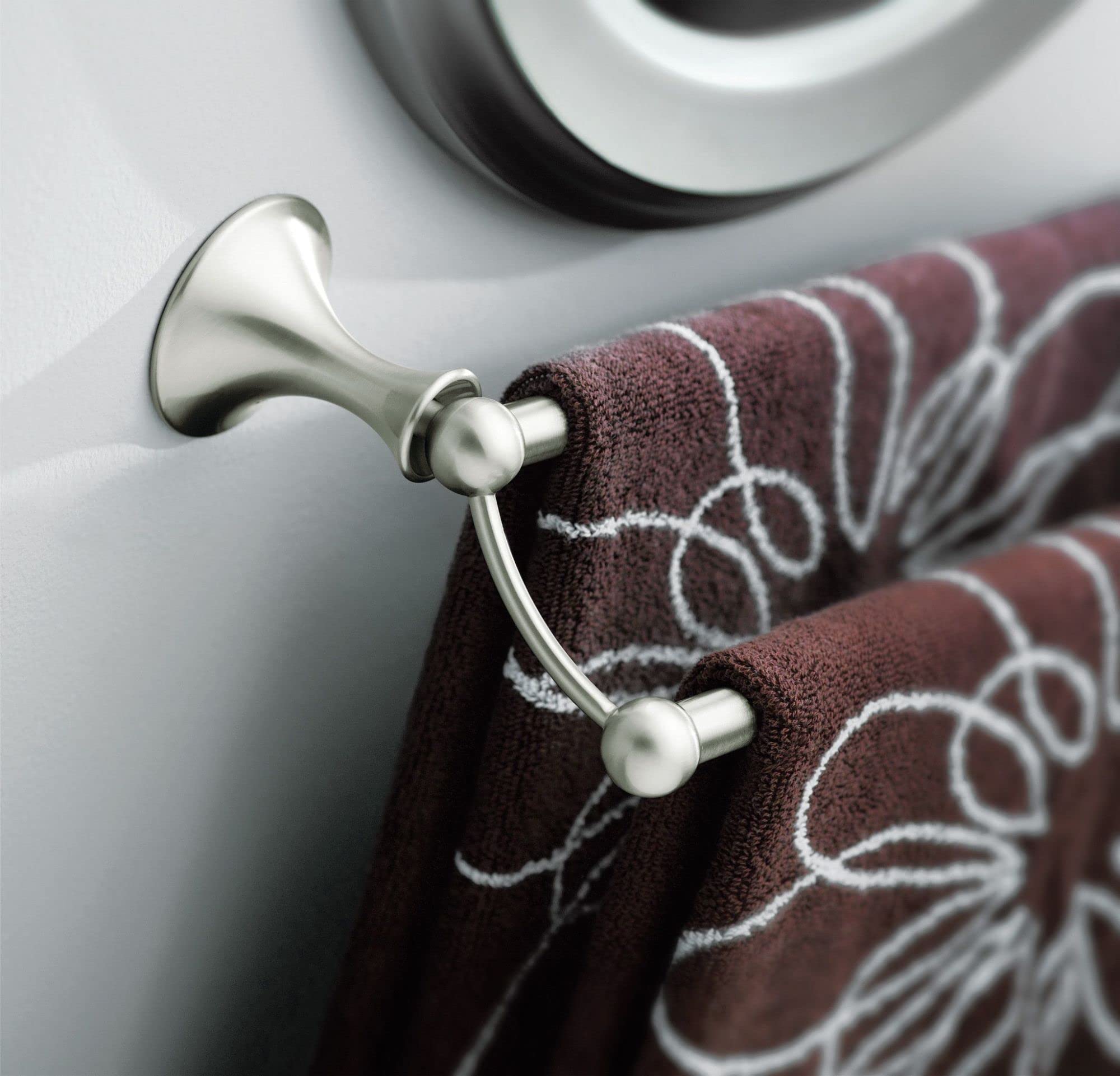 Brushed nickel double towel bar mounted on white wall with burgundy patterned towels draped over both bars.