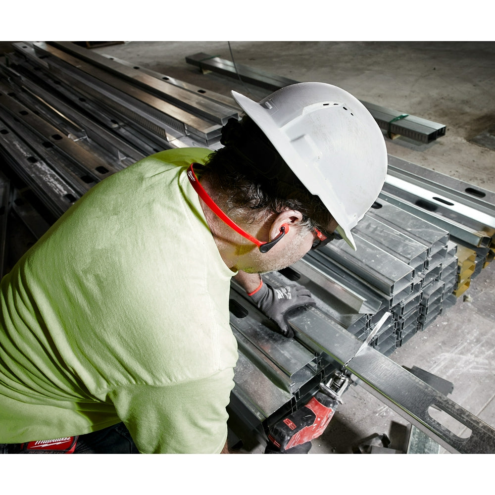 Worker wearing banded ear plugs with red connector band while inspecting metal materials at industrial worksite.