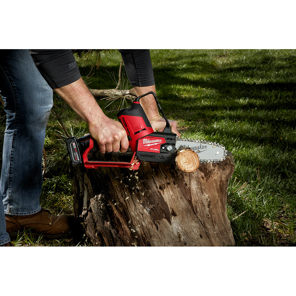 Milwaukee M18 chainsaw with 6-inch cutting bar and chain in use cutting through a log.