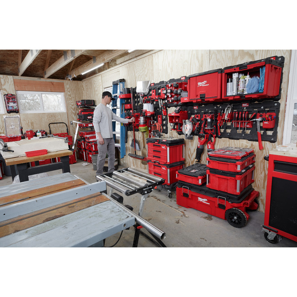 Red and black Milwaukee PACKOUT cabinets and storage units organized on garage wall and floor.