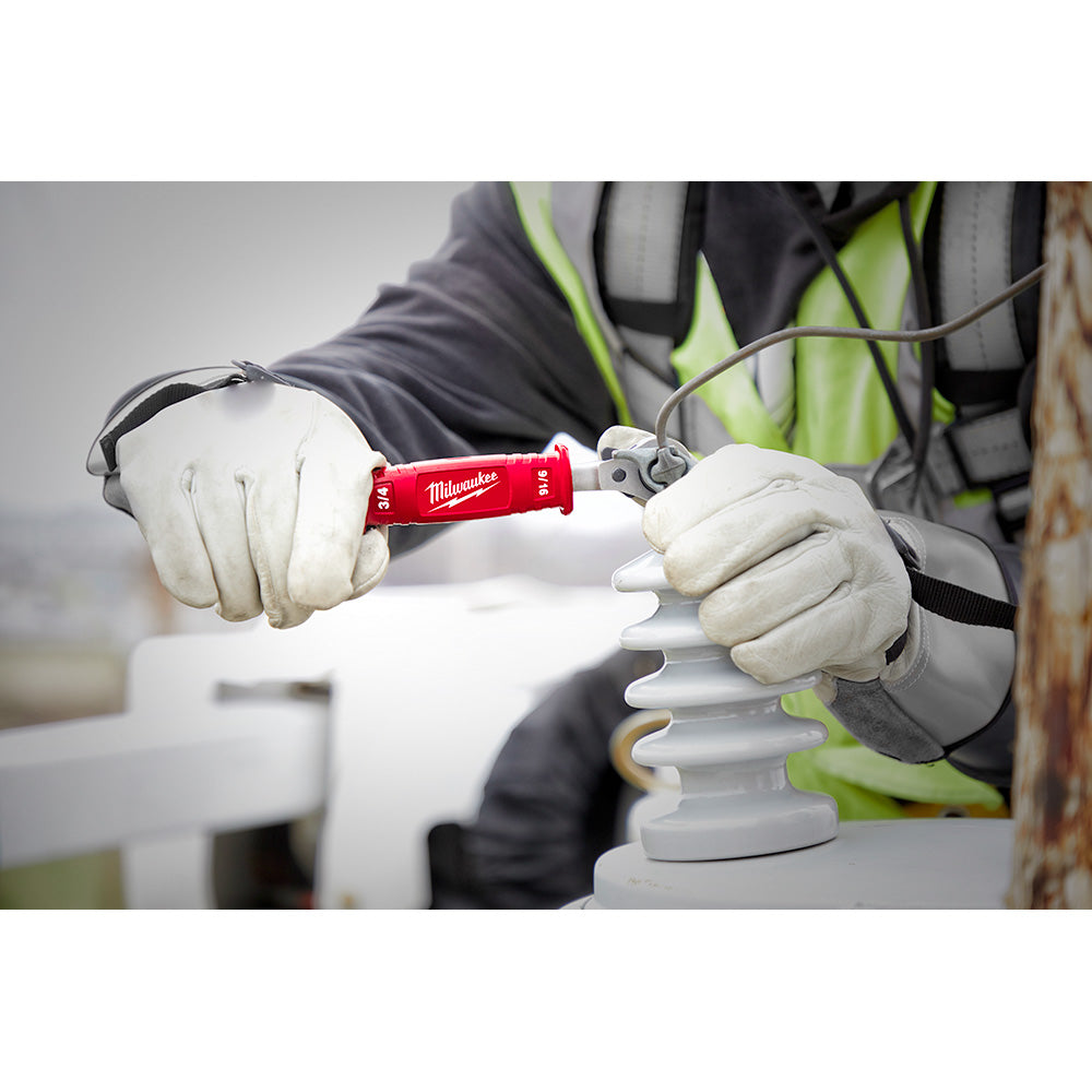 Milwaukee red insulated ratcheting box wrench held in gloved hands over white electrical connector.