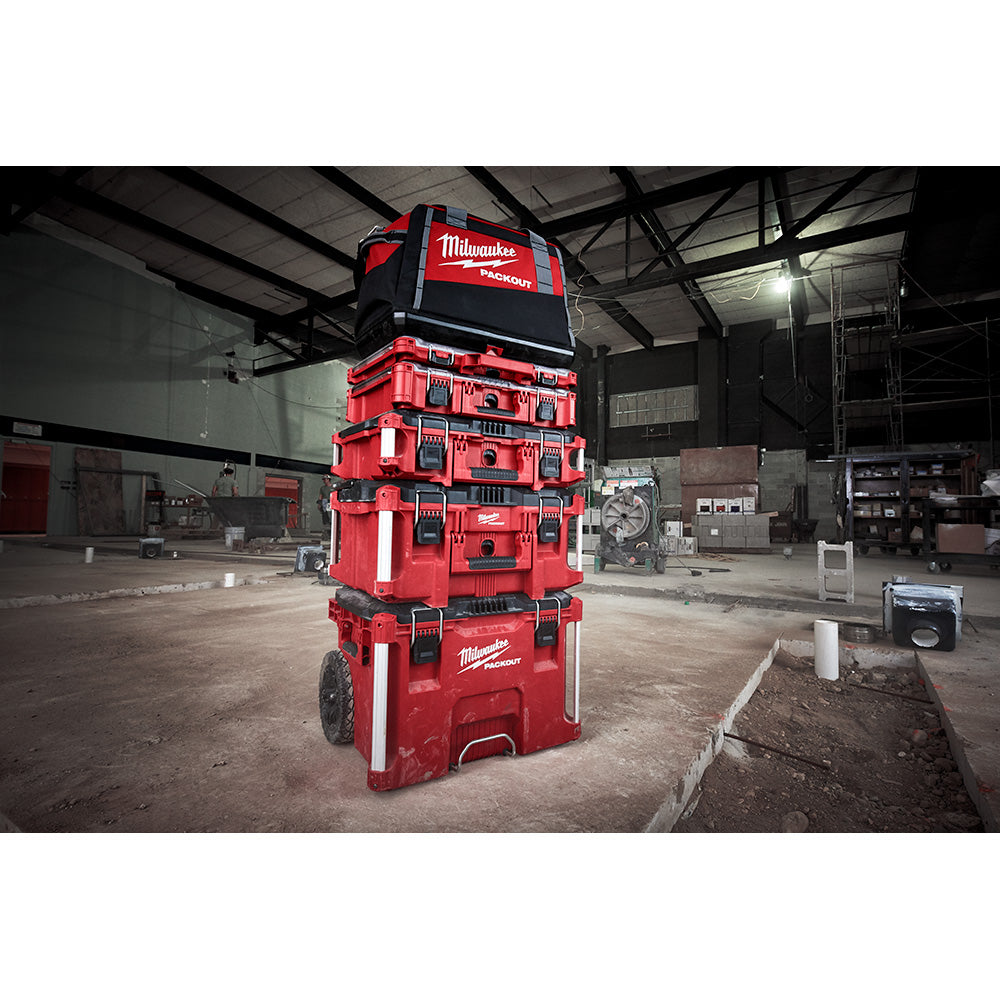 Milwaukee PACKOUT tool bag stacked in red and black modular storage system with wheels.