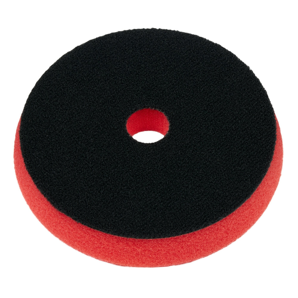 Round foam polishing pad with black top surface, red bottom edge, and center hole for attachment.