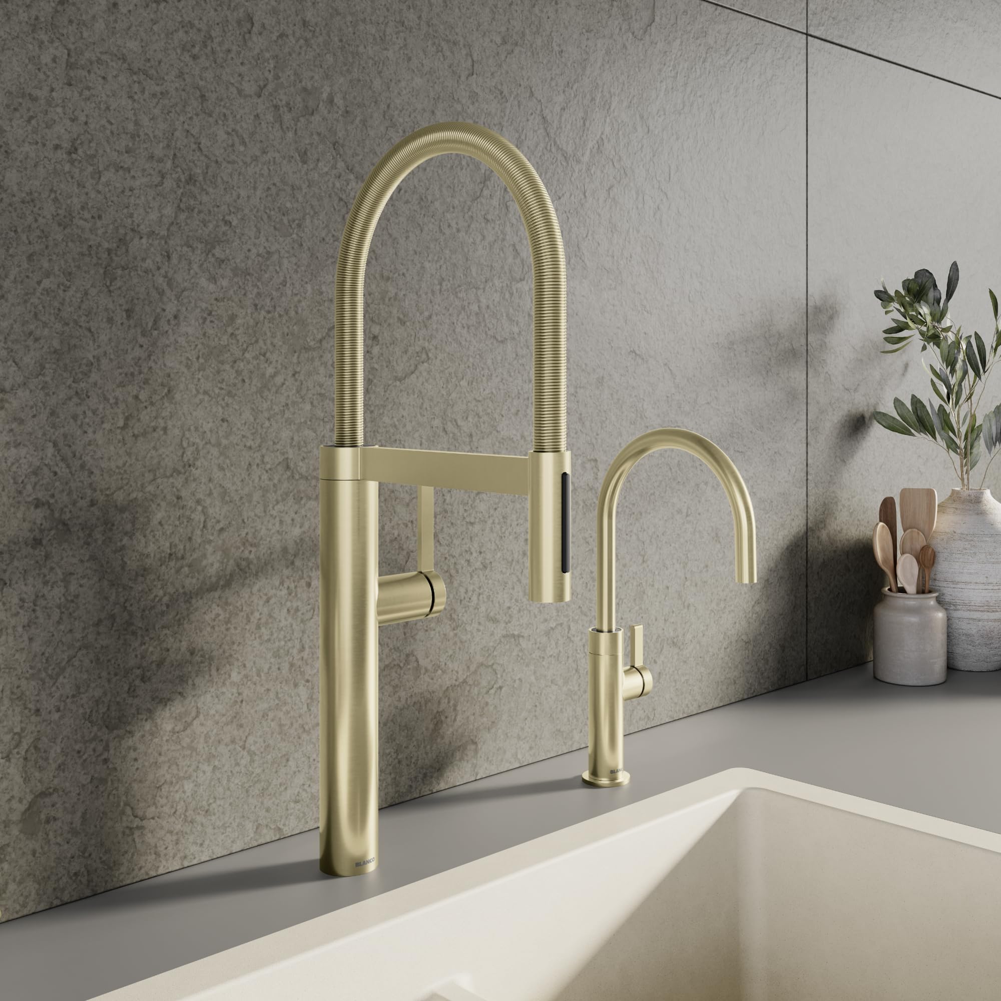 Satin gold pull-down kitchen faucet with tall arched spout and separate spray nozzle mounted above white sink.
