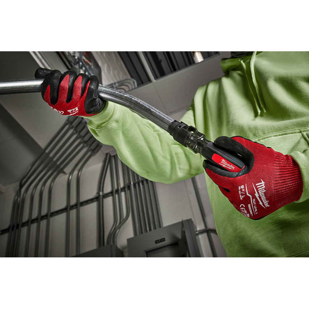 Worker in red and black gloves holding a Milwaukee conduit reamer tool with black shaft against electrical conduit.