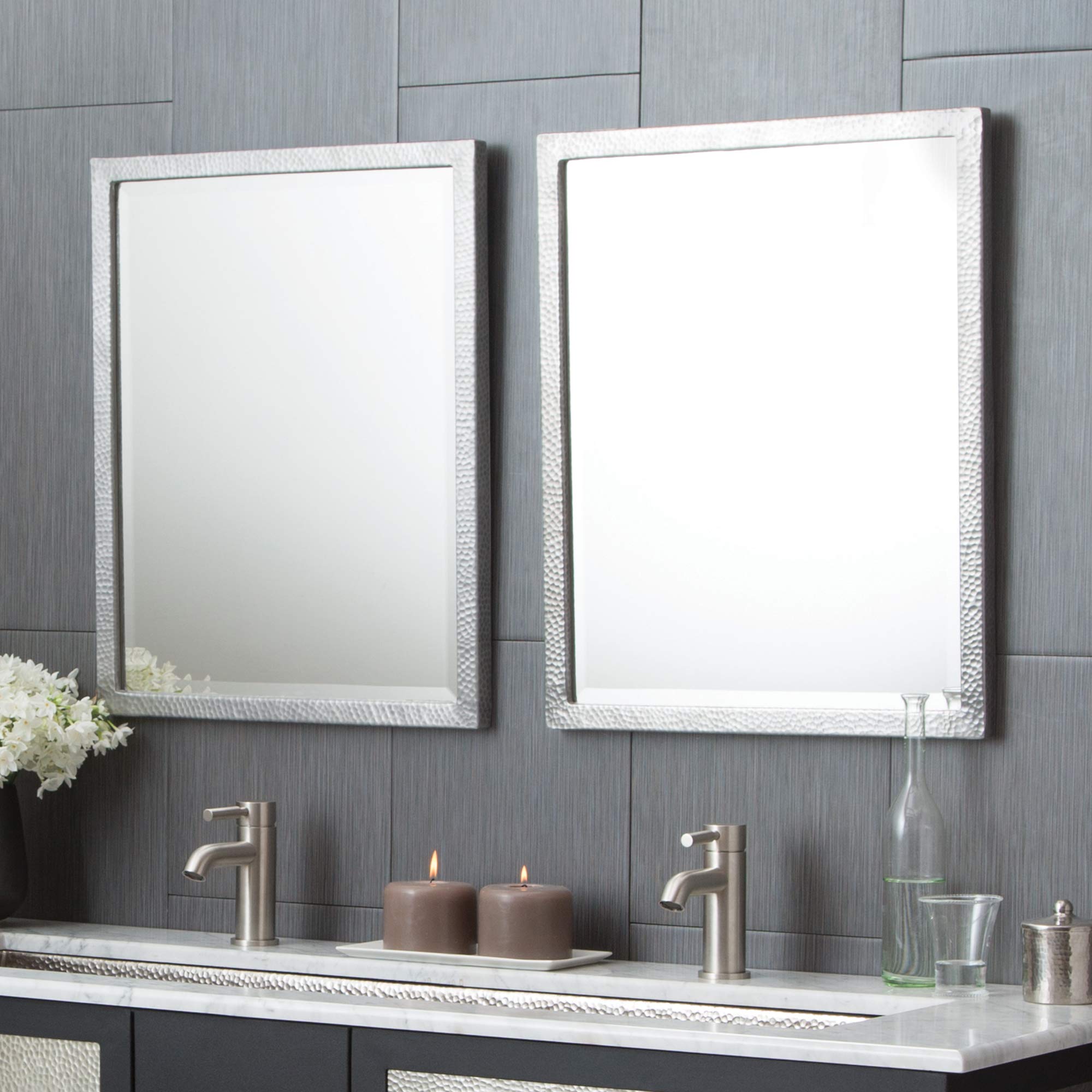 Rectangular wall mirror with textured white frame mounted above bathroom vanity.