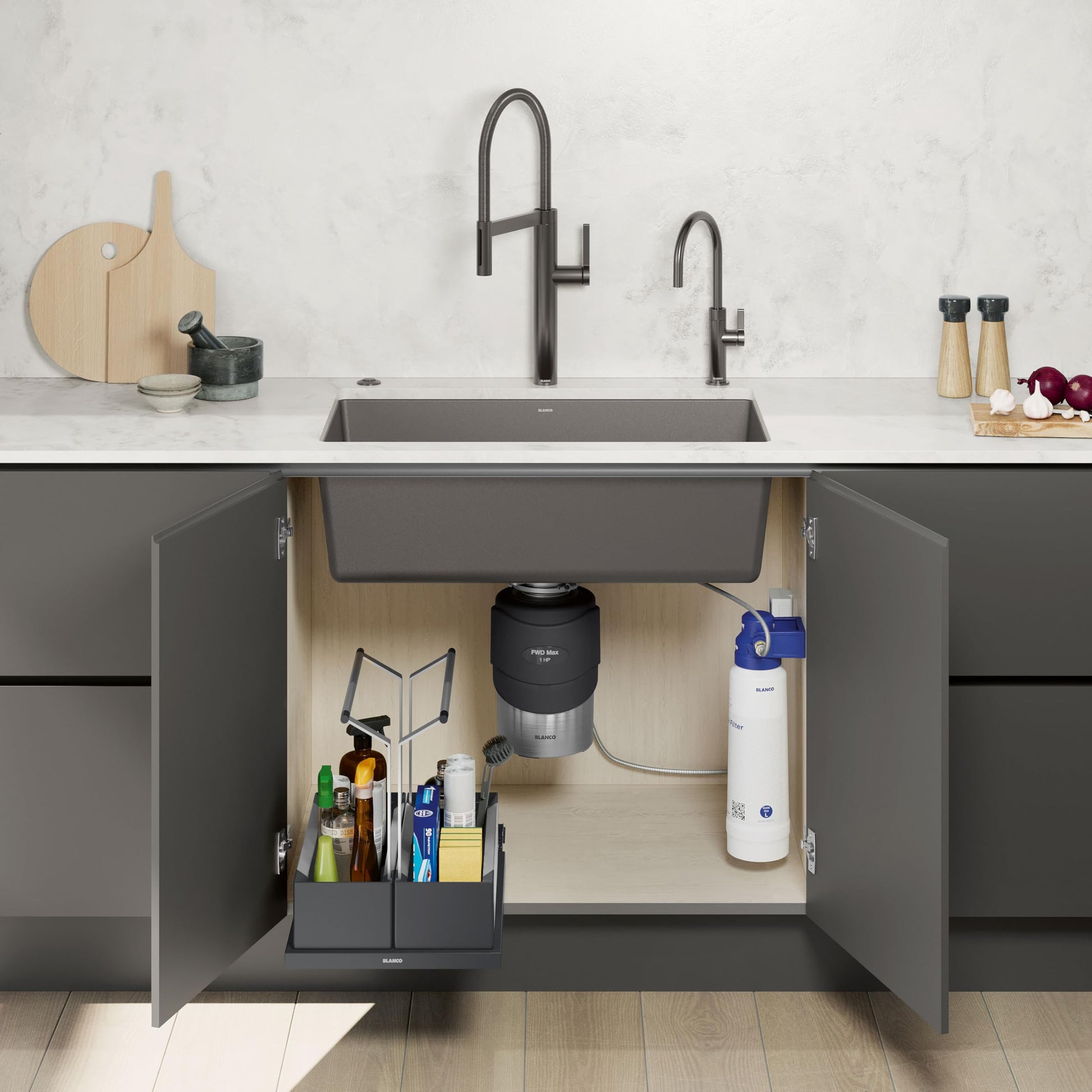 Black food waste disposal unit installed under sink with stainless steel top and black cylindrical motor housing.