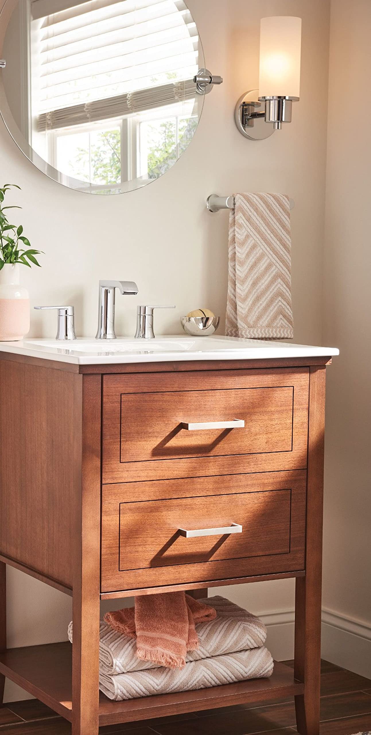 Chrome hand towel bar mounted horizontally on bathroom wall above sink vanity.